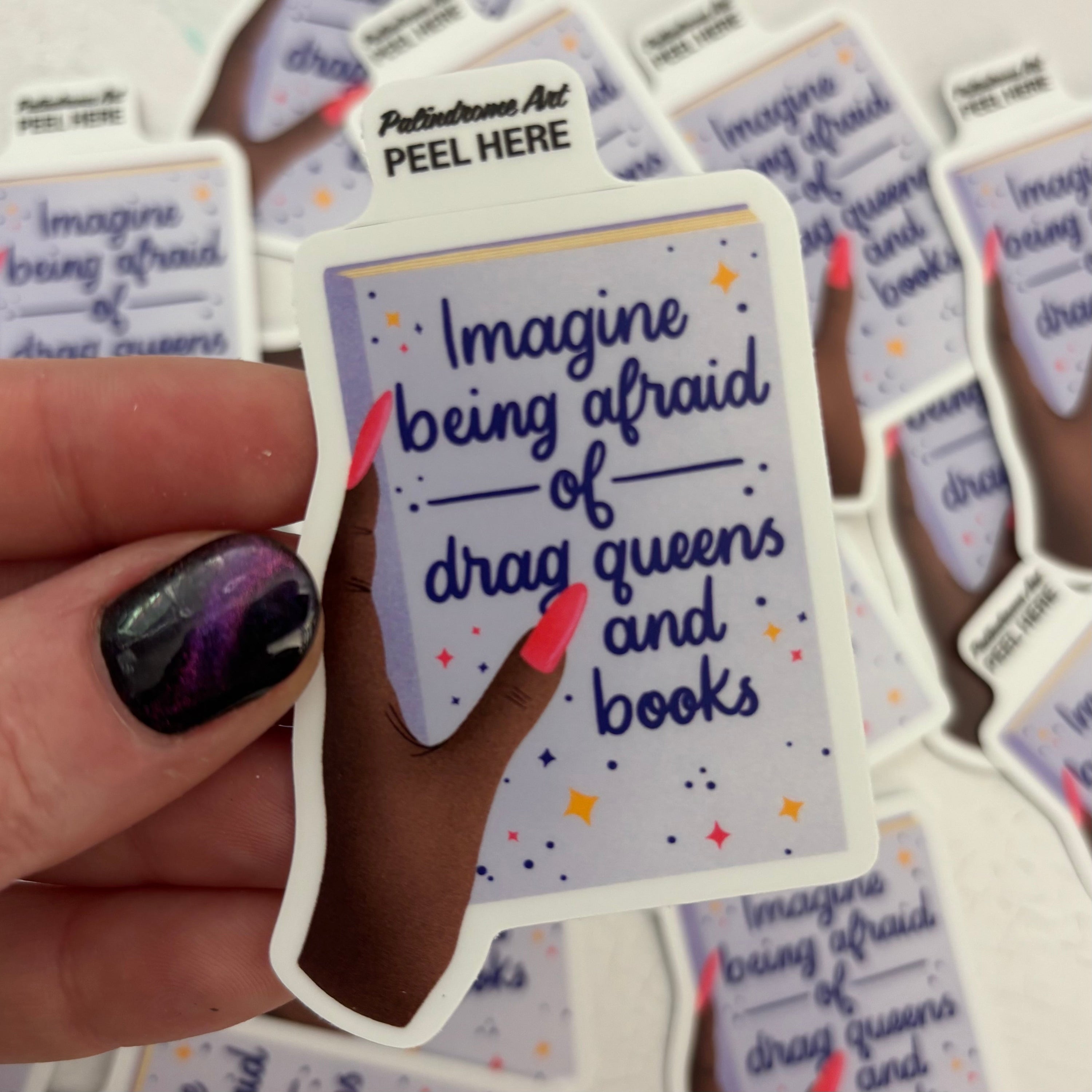 Hand holding a sticker with text &