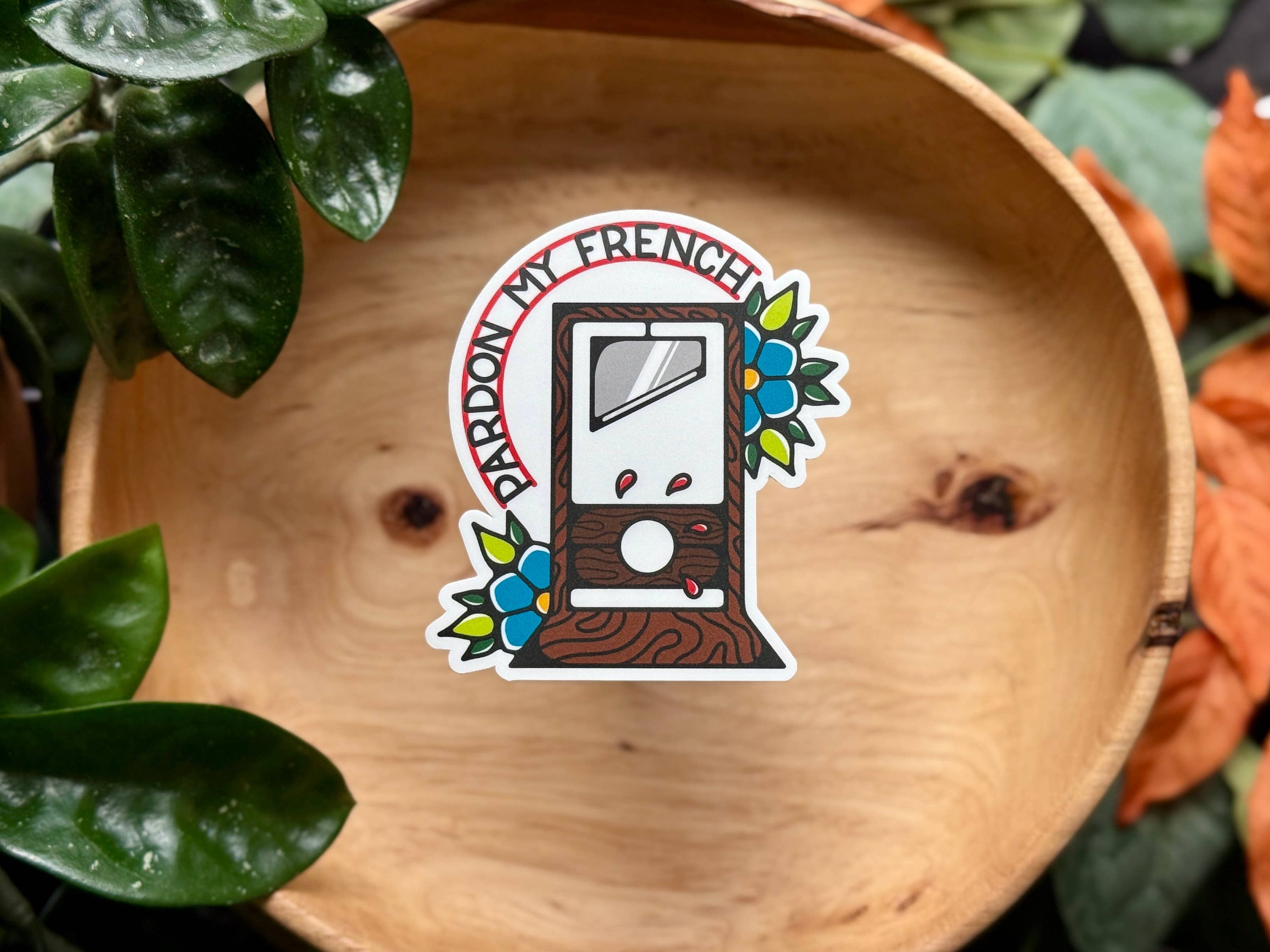 Sticker with a vintage radio design on a wooden surface with plants around