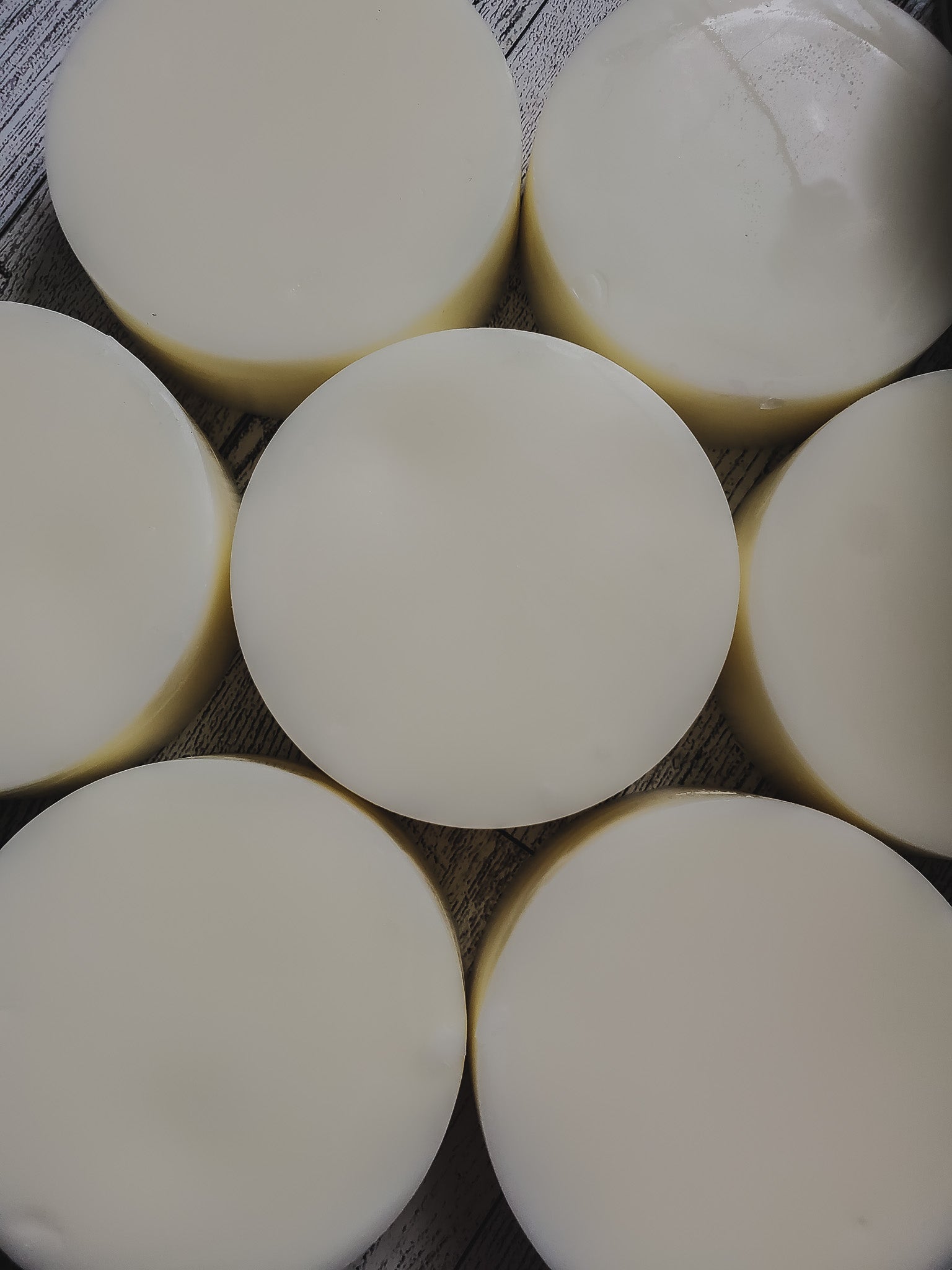 A collection of round conditioner bars arranged in a pattern on a textured background.