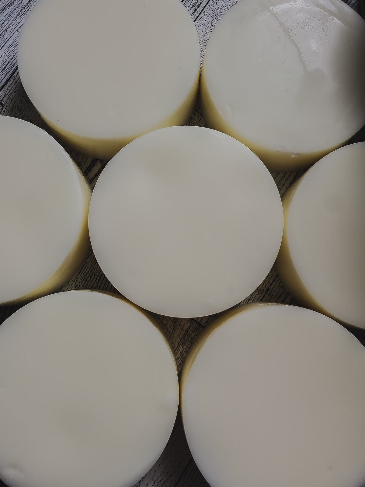 A collection of round conditioner bars arranged in a pattern on a textured background.