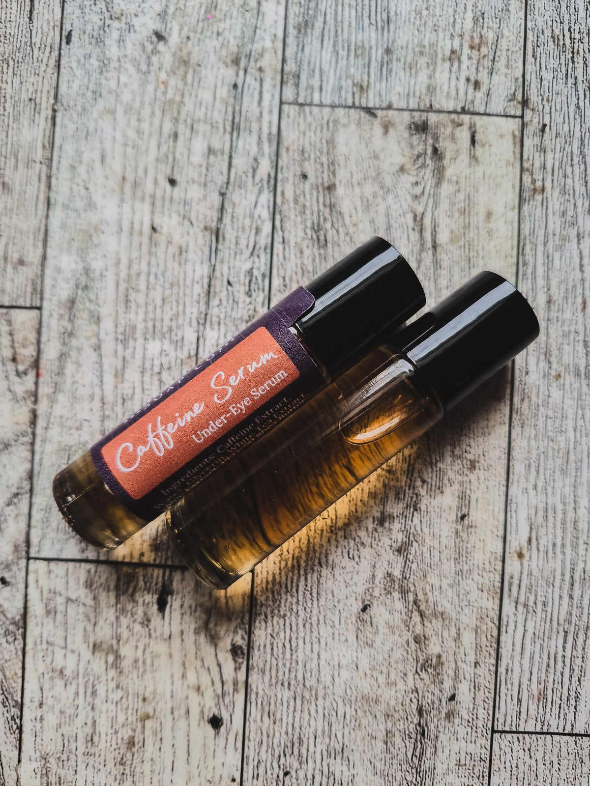 Two bottles of caffeine serum with a dark background