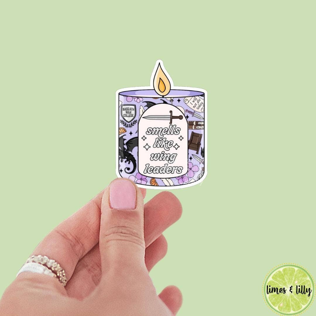 Hand holding a sticker of a candle with text on a light green background