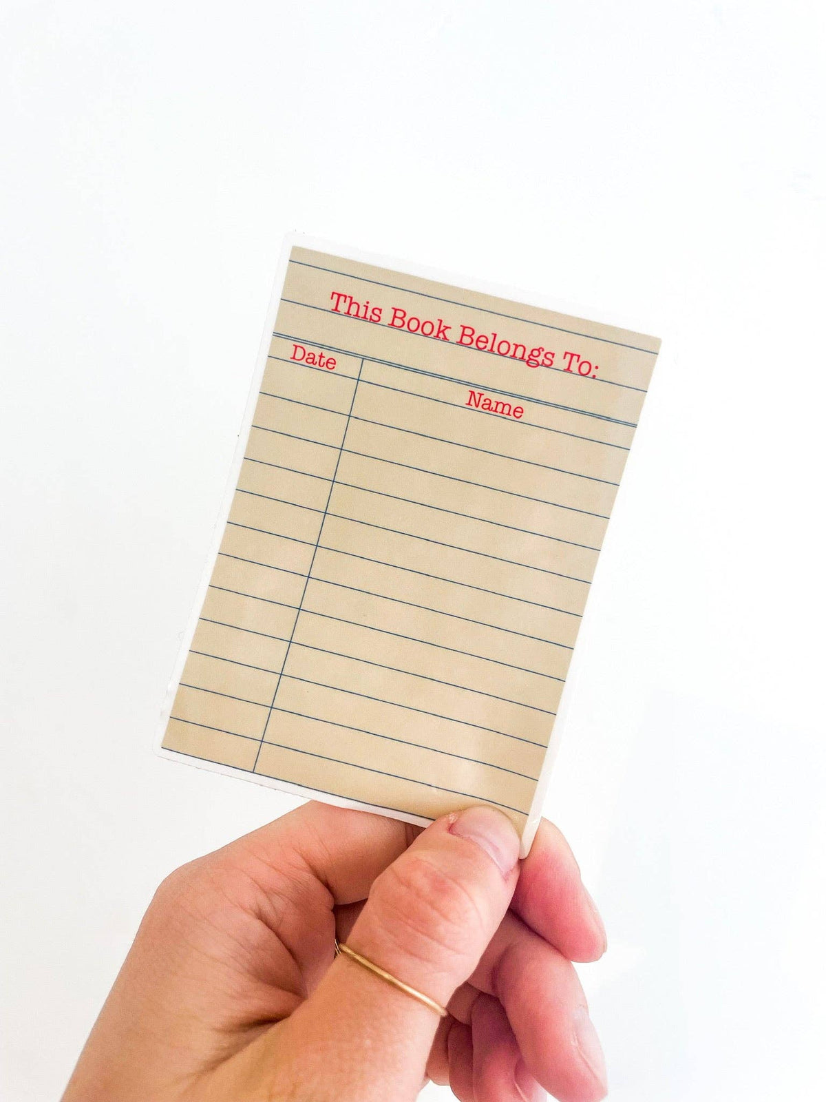 Hand holding a small piece of paper with &