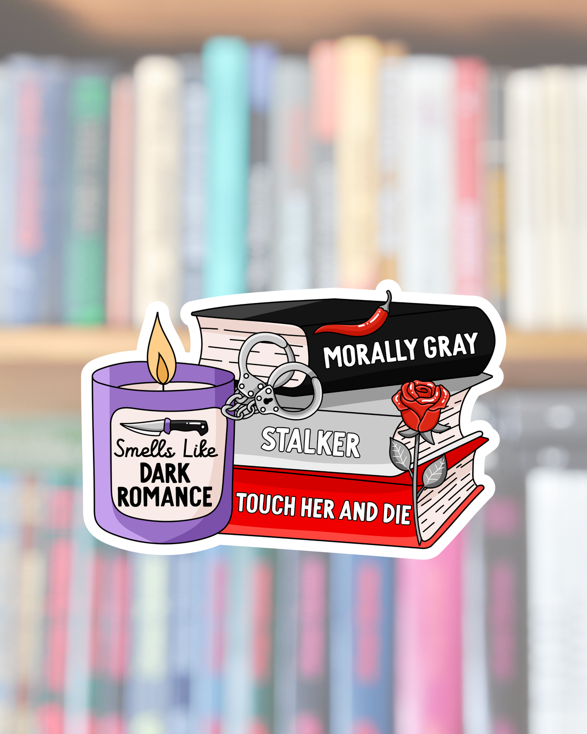A die-cut sticker featuring book and candle-themed graphic elements with text including &