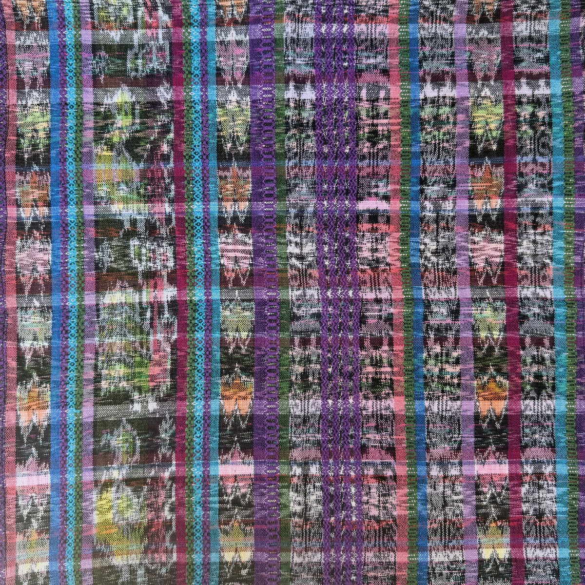 Multicolored plaid fabric pattern with purple, blue, and pink tones.
