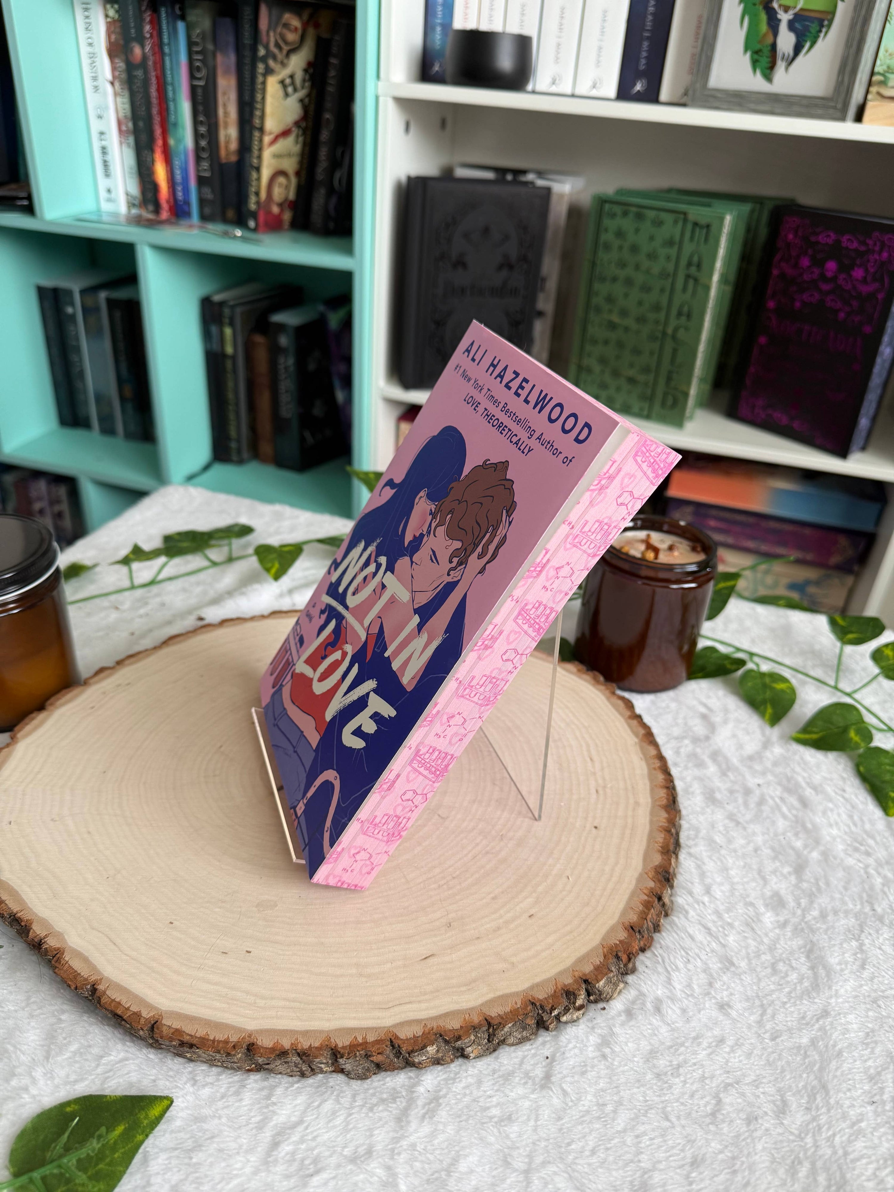 Book with a pink cover featuring a character on a wooden surface with a bookshelf in the background