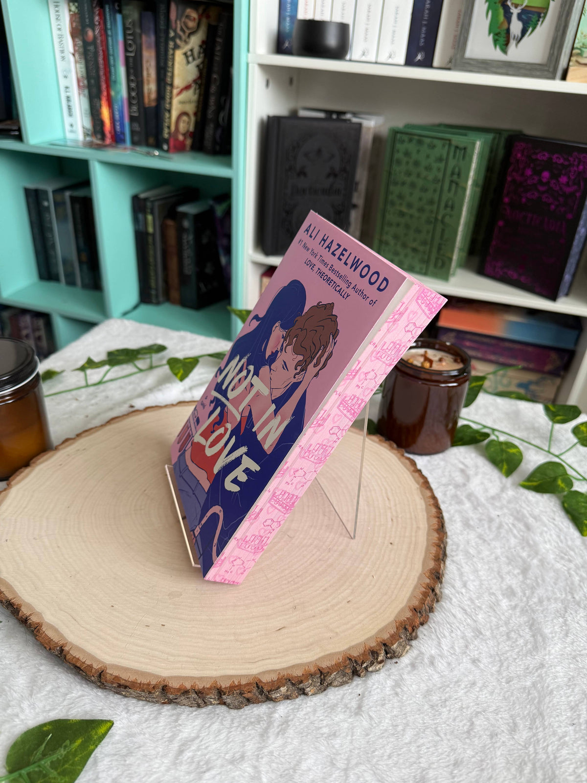 Book with a pink cover featuring a character on a wooden surface with a bookshelf in the background