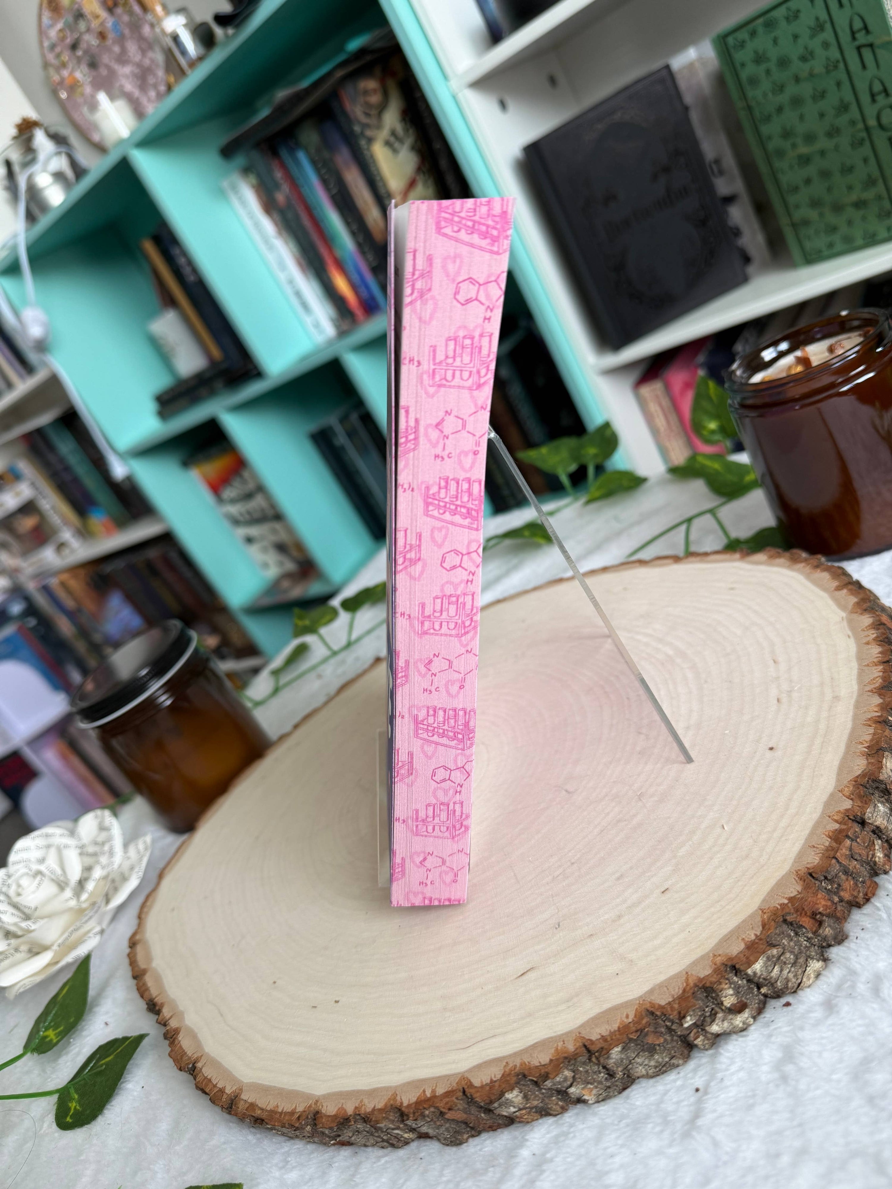 Pink measuring tape on a wooden surface with a bookshelf in the background