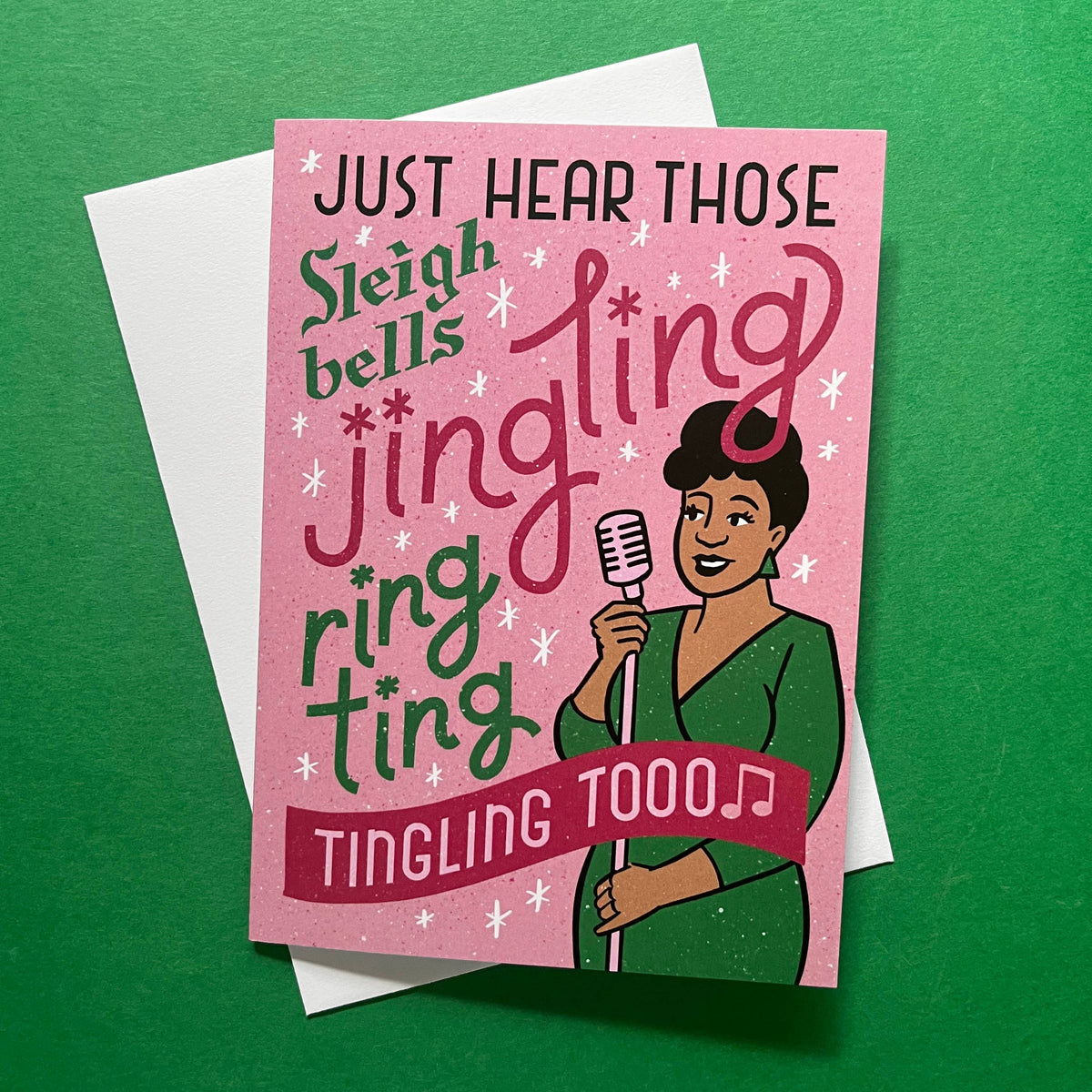 A pink greeting card with holiday-themed text reading &