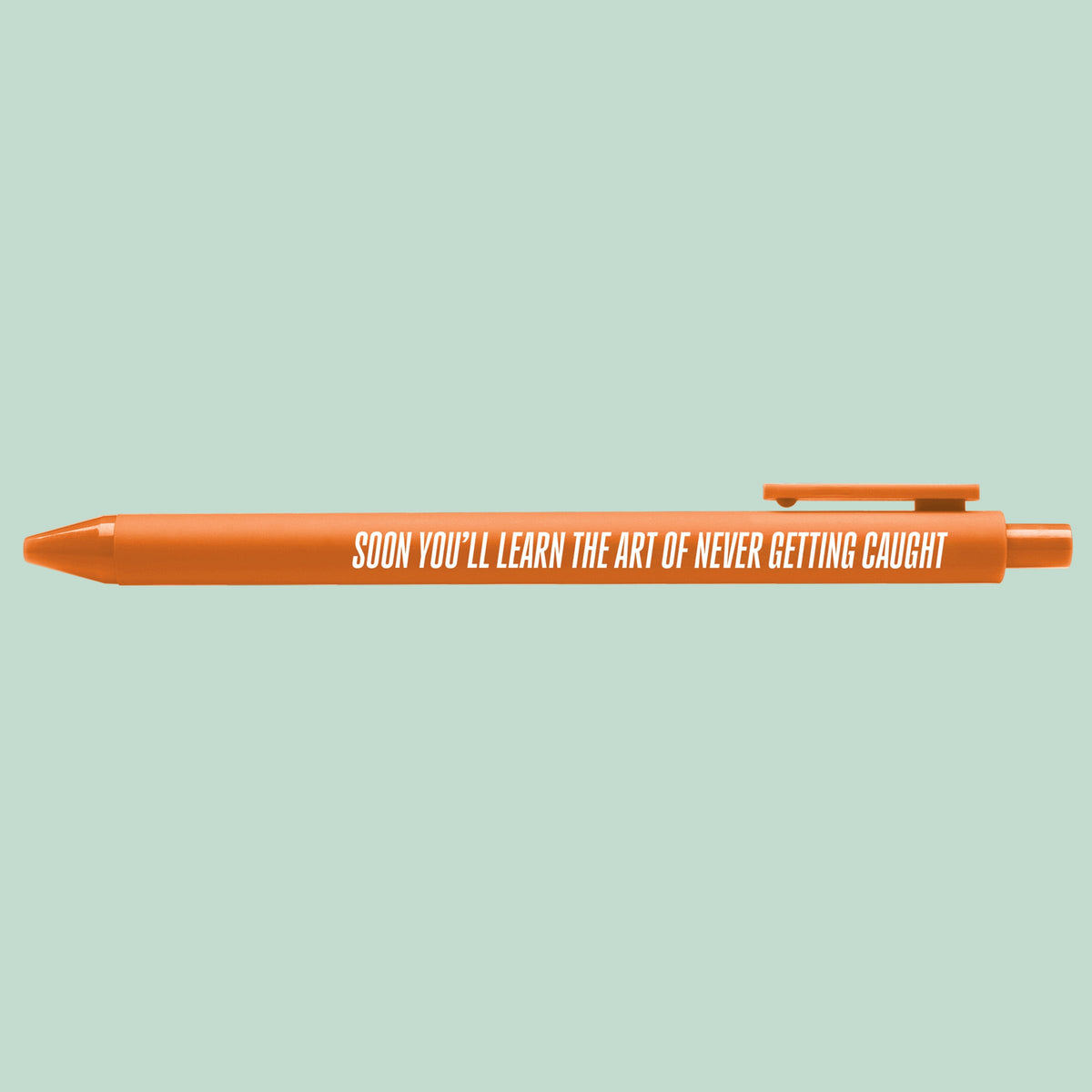 Art of Never Getting Caught pen flat lay — funny pop culture desk pen and stationery gift by indie artist MangoIllustrated