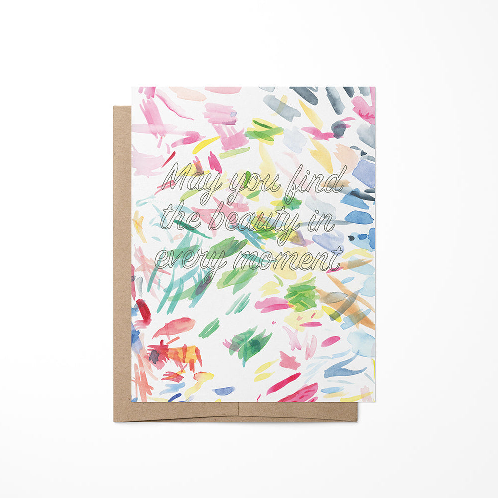 A colorful watercolor painting on a greeting card with a quote about beauty in moments.