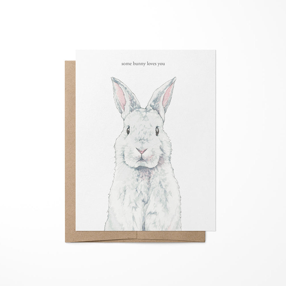 A greeting card with a watercolor painting of a bunny on the front, placed in a brown envelope.