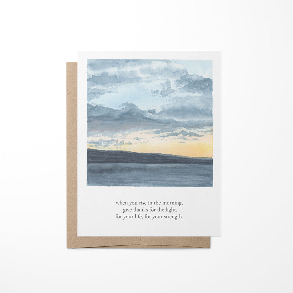A greeting card featuring a watercolor painting of a lakeside sunset with clouds in the sky and a quote by Tecumseh.