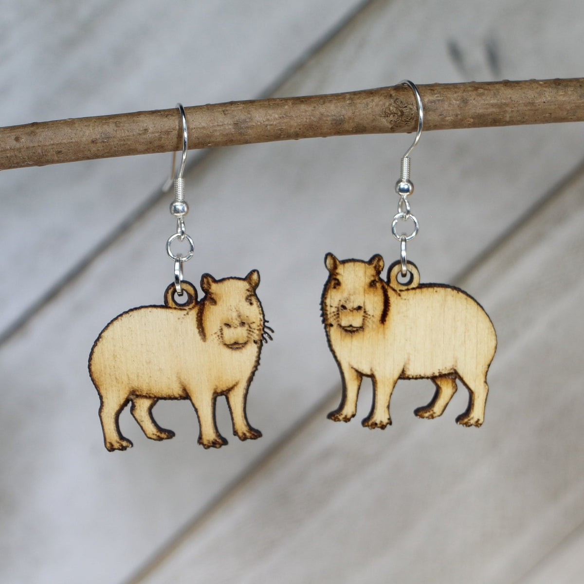 Hand-painted wooden capybara dangle earrings with cute animal design and hypoallergenic sterling silver hooks, lightweight wildlife jewelry for animal lovers and playful style by Cate’s Concepts