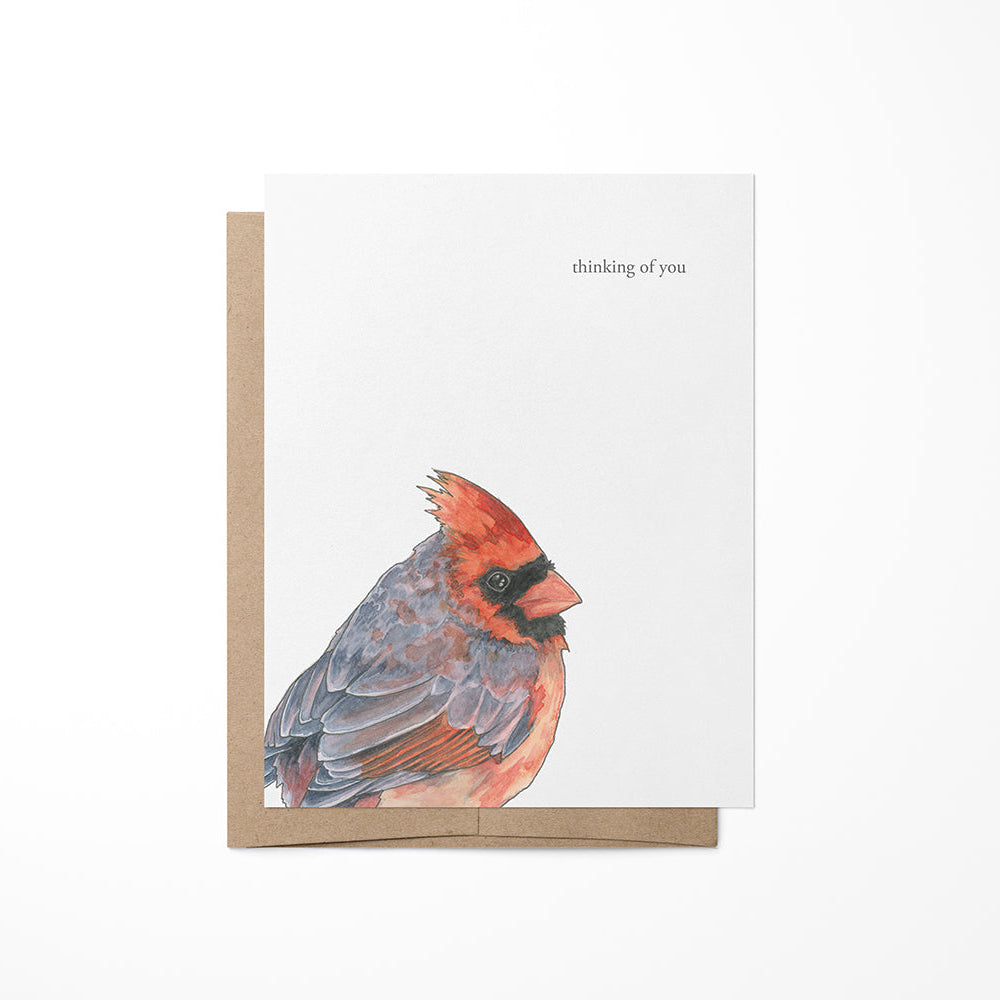 A greeting card featuring a watercolor painting of a red and blue bird, titled &