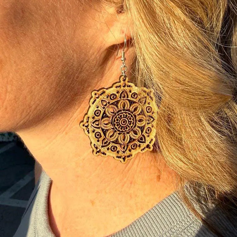 Close-up of a customer wearing handcrafted wooden mandala dangle earrings. This image highlights the precision laser-cut details, natural wood grain, lightweight construction, and hypoallergenic .925 sterling silver hooks. Ideal for bohemian style, yoga enthusiasts, artisan jewelry lovers, and nature-inspired fashion.