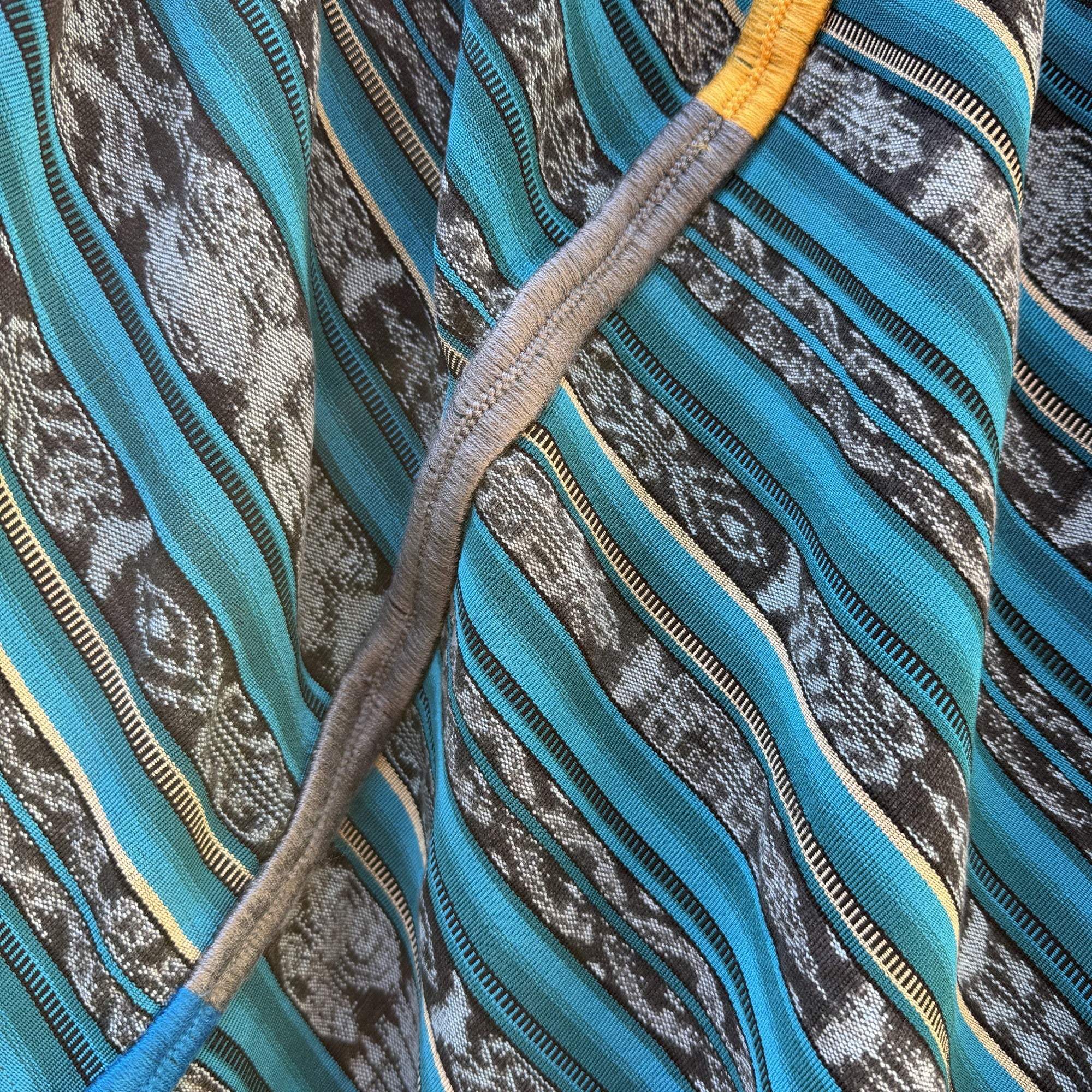 Close-up of a textured fabric with blue, gray, and yellow patterns
