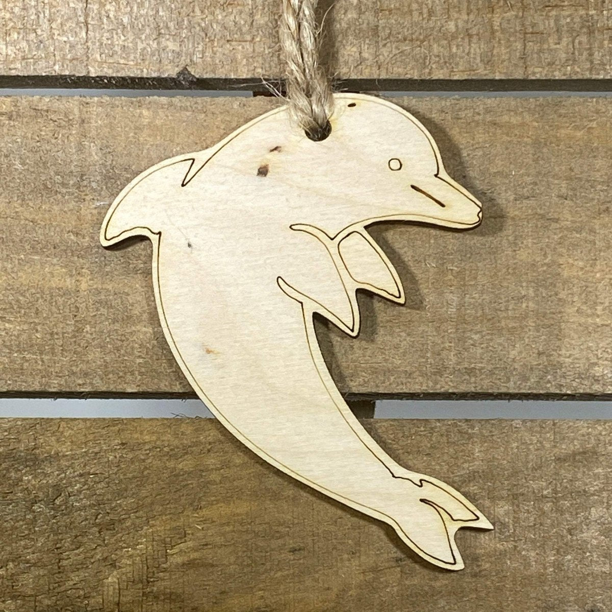 Hand-painted wooden dolphin Christmas ornament featuring a sleek ocean-inspired design with curved body and playful marine details, festive holiday decor for beach lovers and ocean enthusiasts by Cate’s Concepts