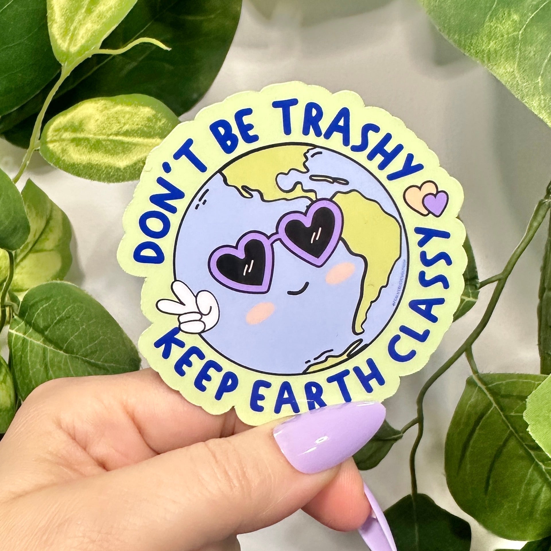 Sticker with Earth design with purple heart sunglasses and peace fingers with wrapped circular text &