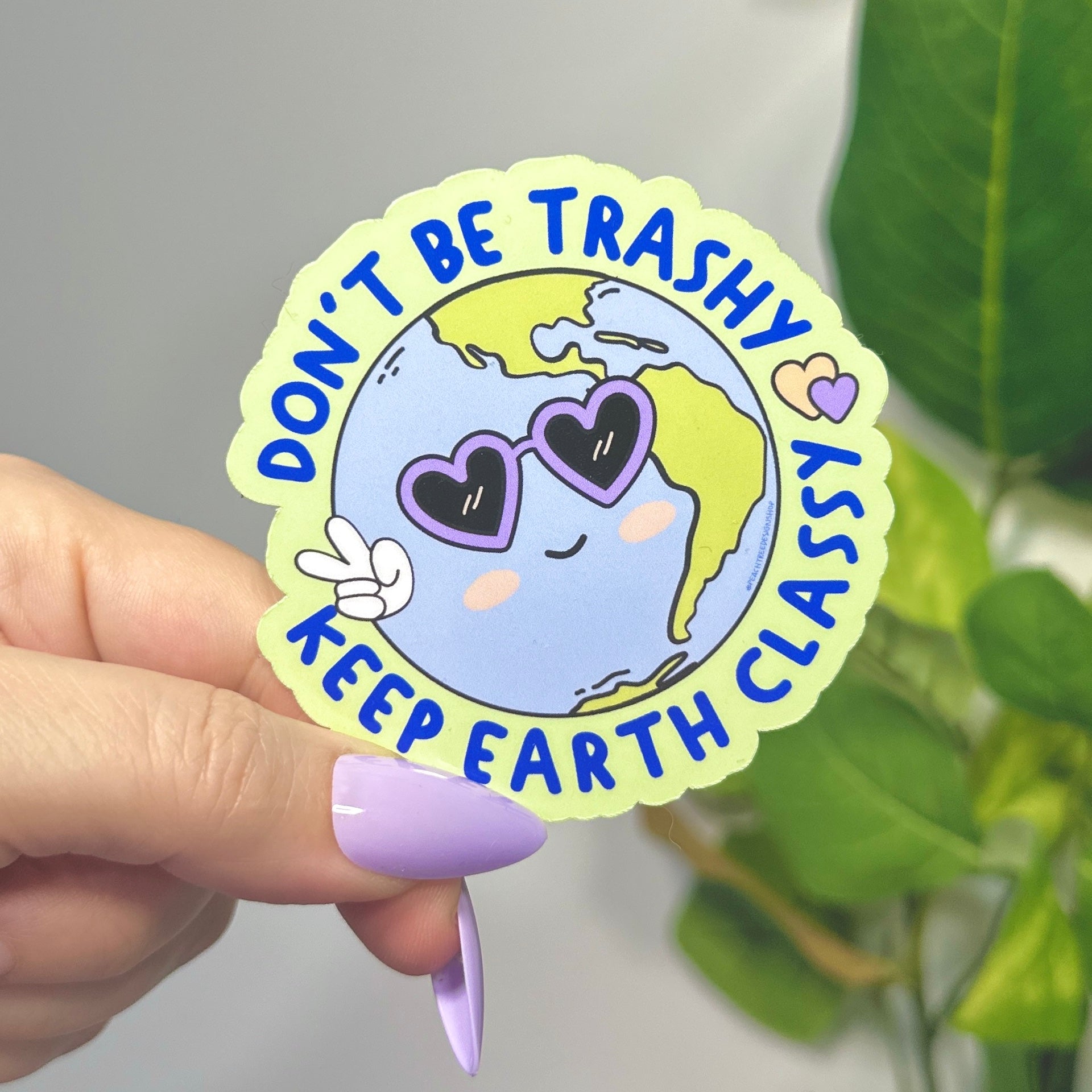 Sticker with Earth design with purple heart sunglasses and peace fingers with wrapped circular text &