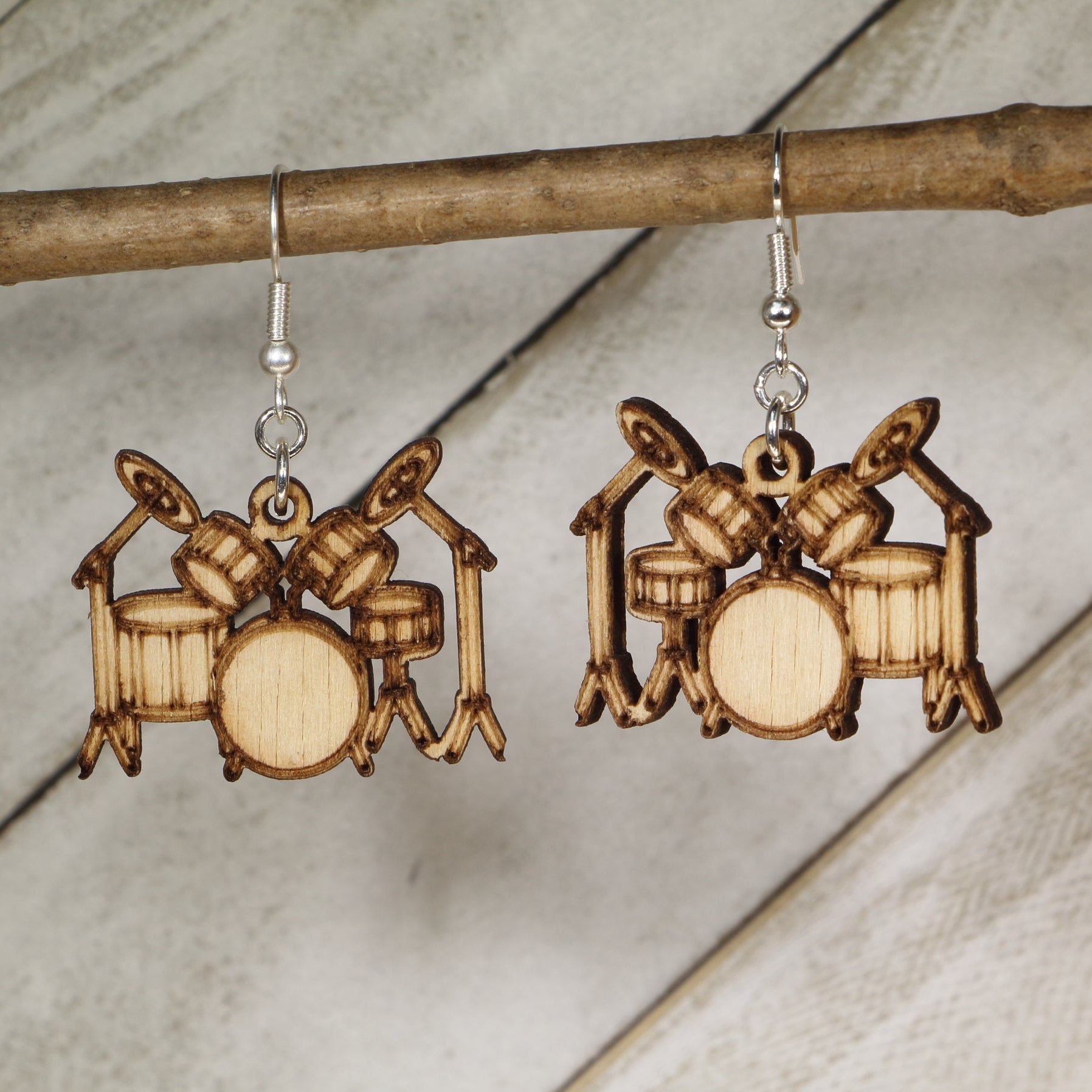 Hand-painted wooden drum set dangle earrings with detailed drum kit design and hypoallergenic sterling silver hooks, lightweight music jewelry for drummers, band members, and percussion lovers