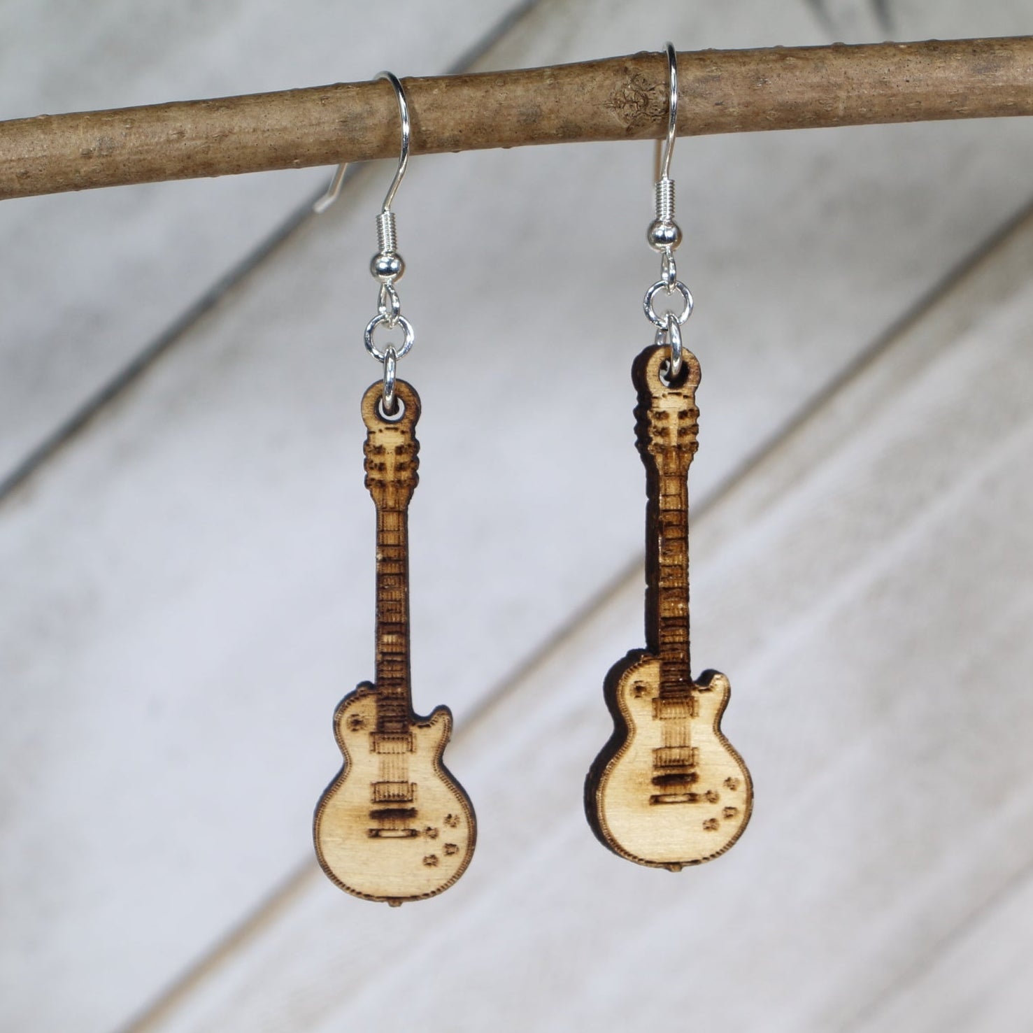 Hand-painted wooden electric guitar dangle earrings featuring a detailed guitar body with strings and pickups and hypoallergenic sterling silver hooks, lightweight jewelry for rock musicians and music lovers