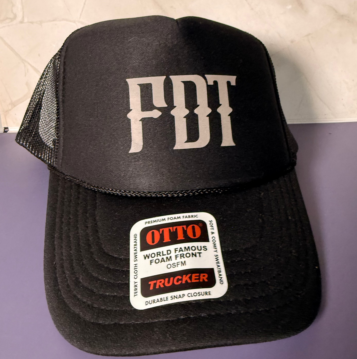 A black trucker hat with &