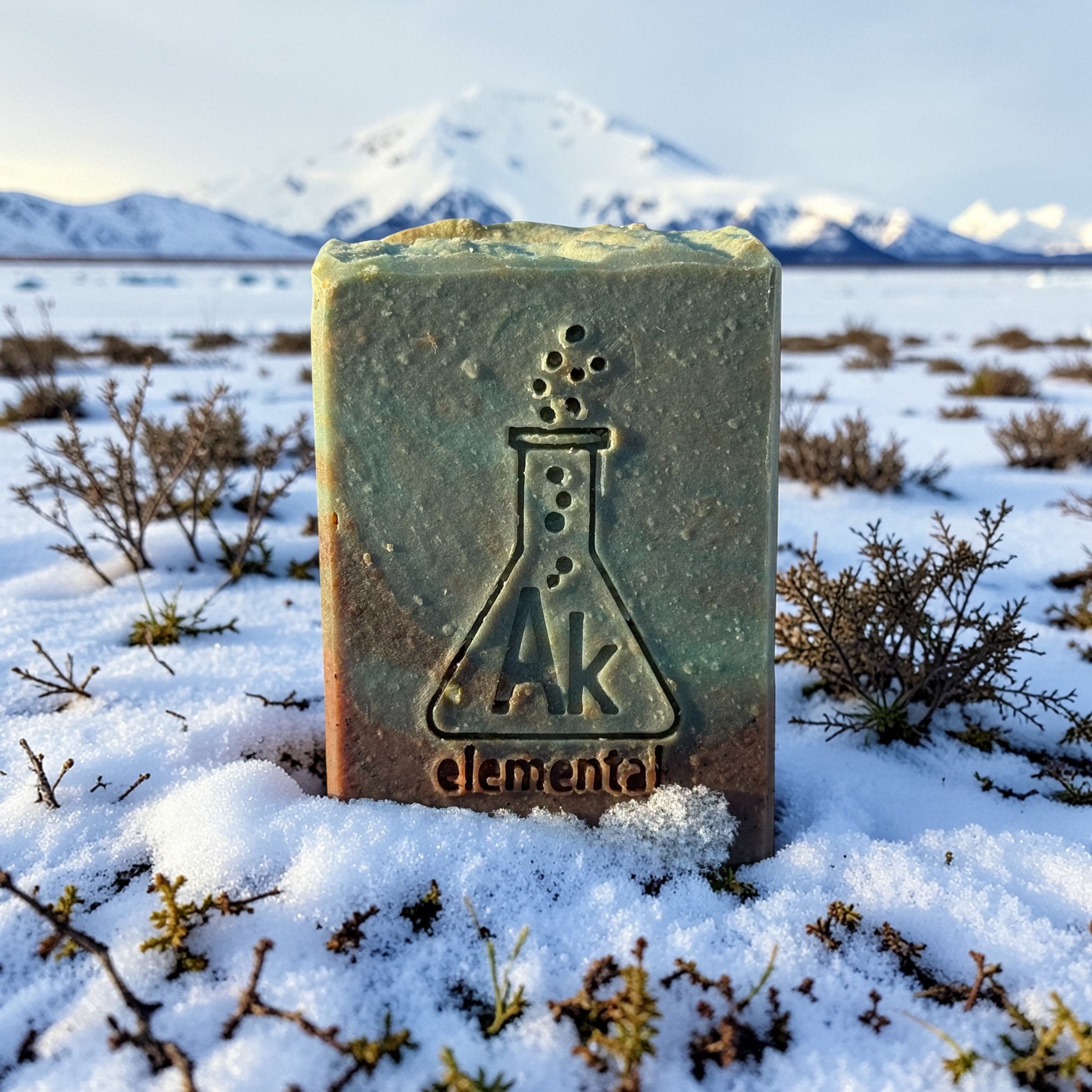 Green and brown soap sitting on a snowy field.