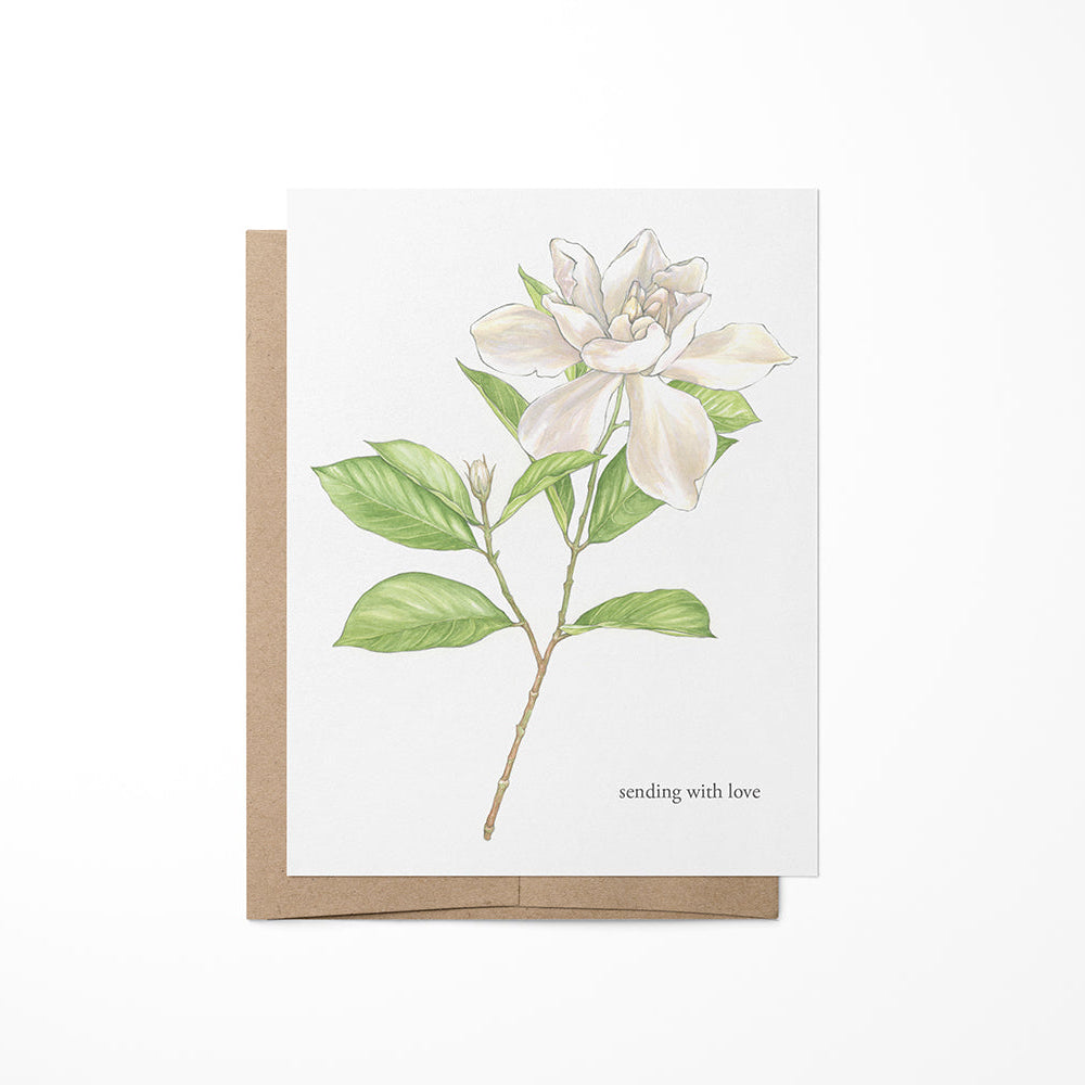 A greeting card featuring a watercolor painting of a gardenia plant on a white background, with a Kraft envelope.