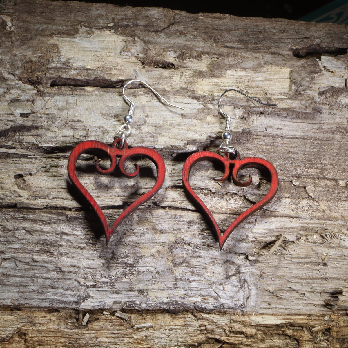 Hand-painted red wooden heart dangle earrings with an elegant open-heart scrollwork design on hypoallergenic .925 sterling silver hooks. Lightweight romantic jewelry perfect for Valentine&