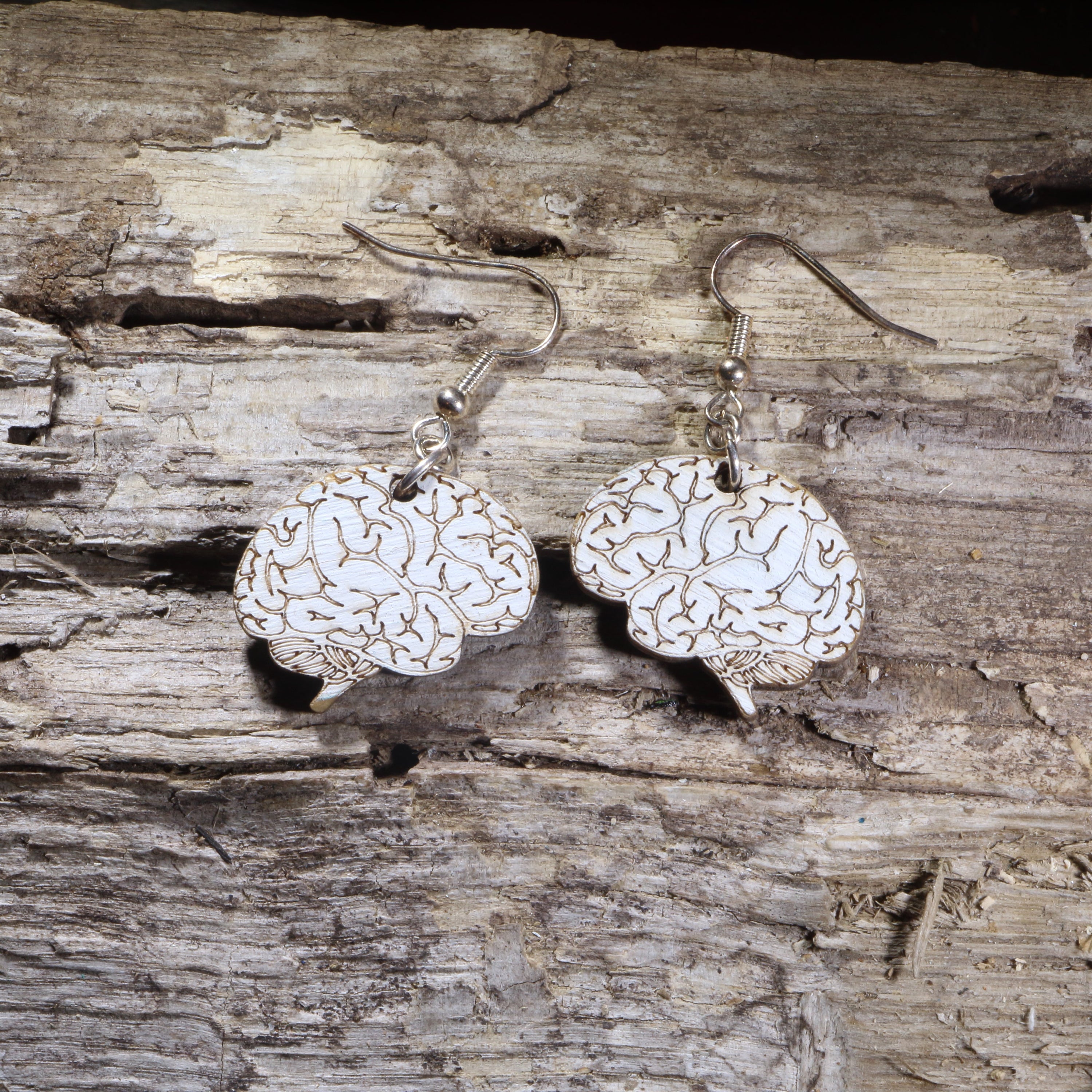 Hand-painted wooden brain dangle earrings featuring an anatomically inspired brain design on lightweight wood with hypoallergenic .925 sterling silver hooks. Perfect for neurologists, neuroscientists, psychologists, medical students, science teachers, healthcare professionals, and unique anatomy jewelry lovers.