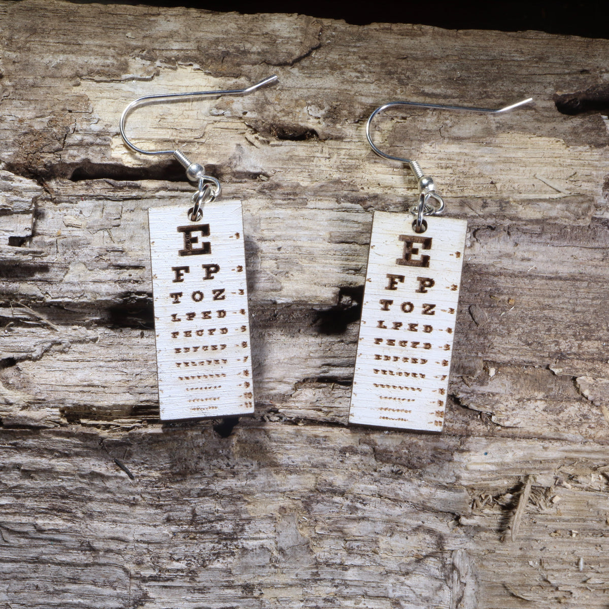 Hand-painted wooden eye chart dangle earrings featuring a classic vision test chart design on lightweight wood with hypoallergenic .925 sterling silver hooks. Perfect for optometrists, ophthalmologists, eye doctors, optometry students, vision care professionals, and unique medical-themed jewelry lovers.