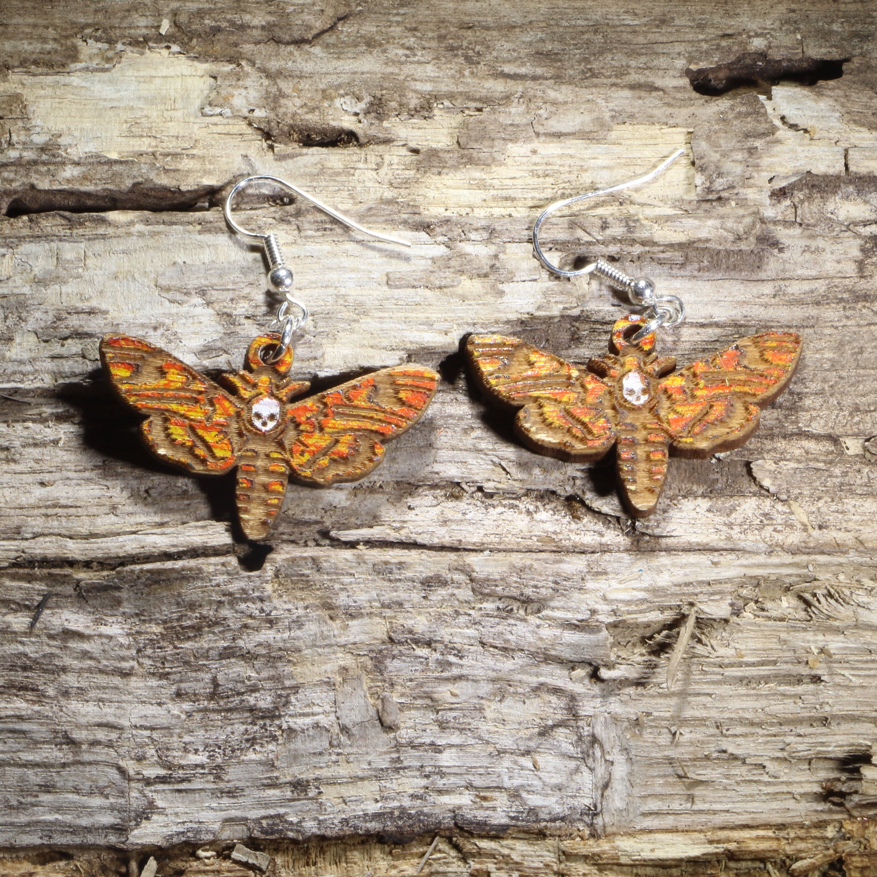 Hand-painted wooden hawk moth dangle earrings featuring detailed orange, gold, and brown wings on hypoallergenic .925 sterling silver hooks. Lightweight moth-inspired jewelry for insect lovers, entomologists, nature enthusiasts, cottagecore fashion, and wildlife gifts.