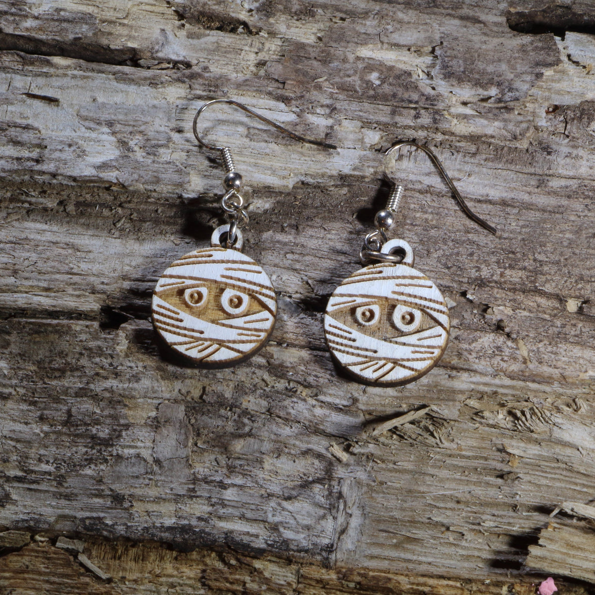 Hand-painted wooden mummy dangle earrings featuring a wrapped Halloween mummy with spooky details. Lightweight Halloween earrings with hypoallergenic .925 sterling silver hooks, perfect for spooky season, trick-or-treat events, Halloween parties, haunted attractions, and anyone who loves creepy-cute Halloween jewelry.