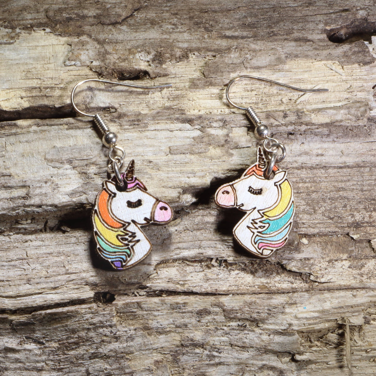 Hand-painted wooden unicorn head dangle earrings featuring a white unicorn with a rainbow mane and gold horn on hypoallergenic .925 sterling silver hooks. Lightweight fantasy-inspired jewelry for unicorn lovers, magical creature fans, colorful accessory collectors, and whimsical gift giving.