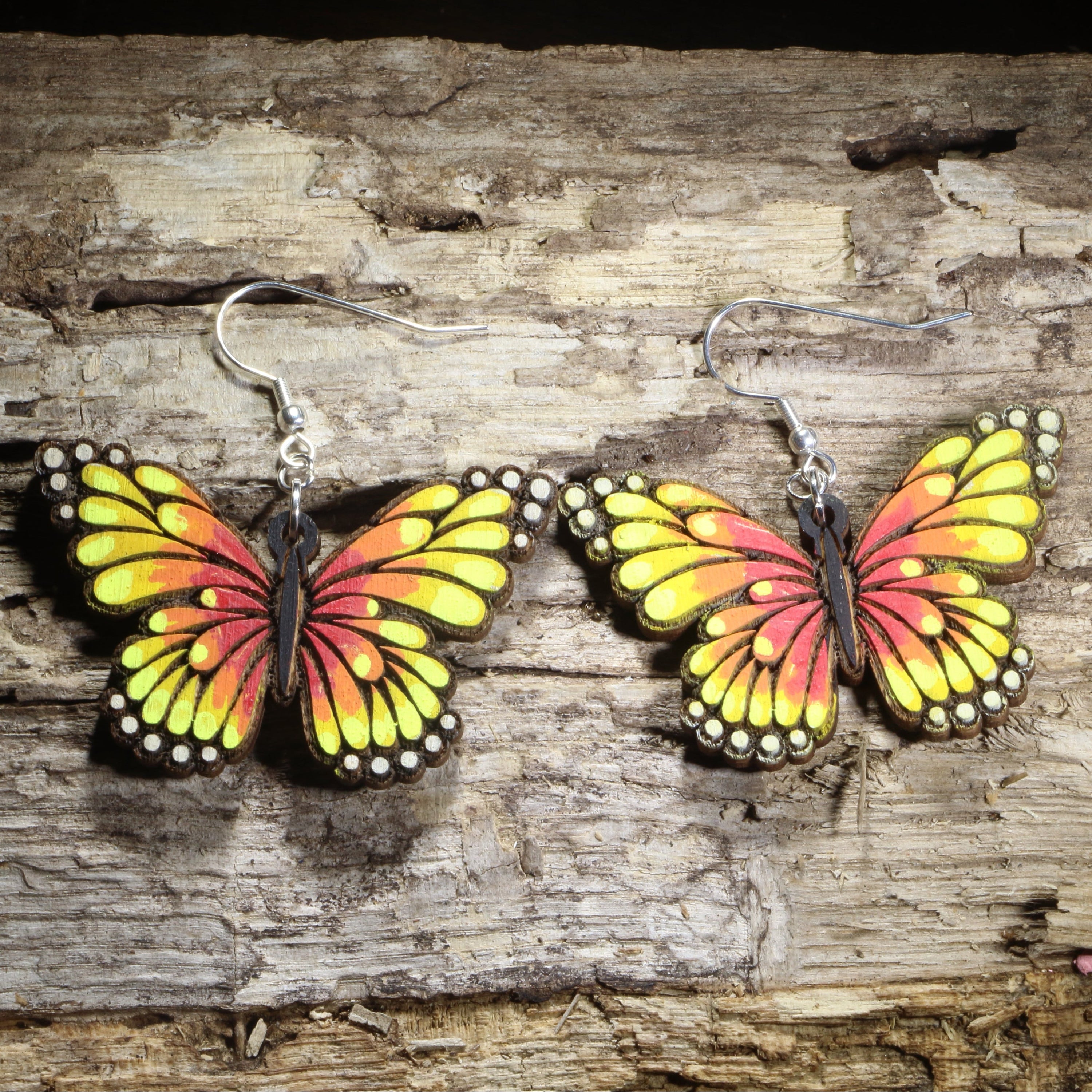 Handmade sunset butterfly wooden dangle earrings featuring colorful butterfly wings inspired by warm sunset hues with detailed engraved accents. Lightweight butterfly earrings crafted from wood with hypoallergenic .925 sterling silver hooks, perfect for butterfly lovers, nature enthusiasts, gardeners, insect fans, and colorful wildlife jewelry collectors.