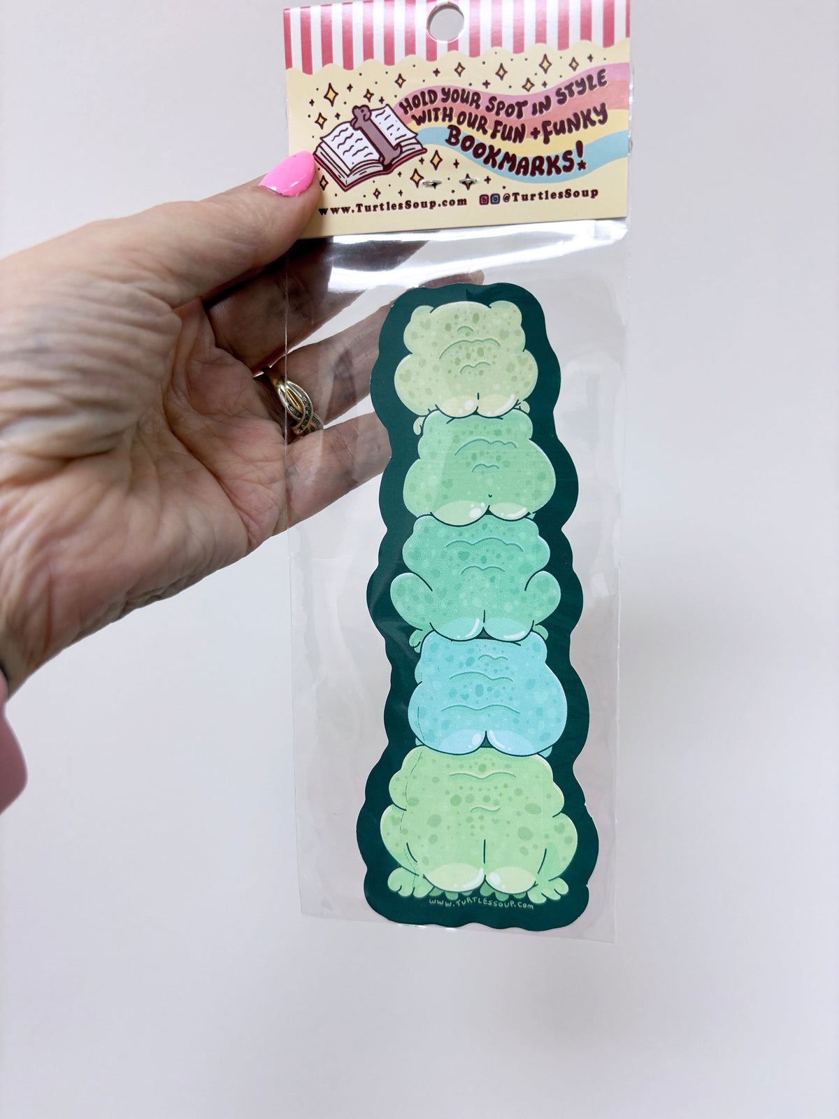 Hand holding a set of green and blue gradient bookmarks with packaging labeled &