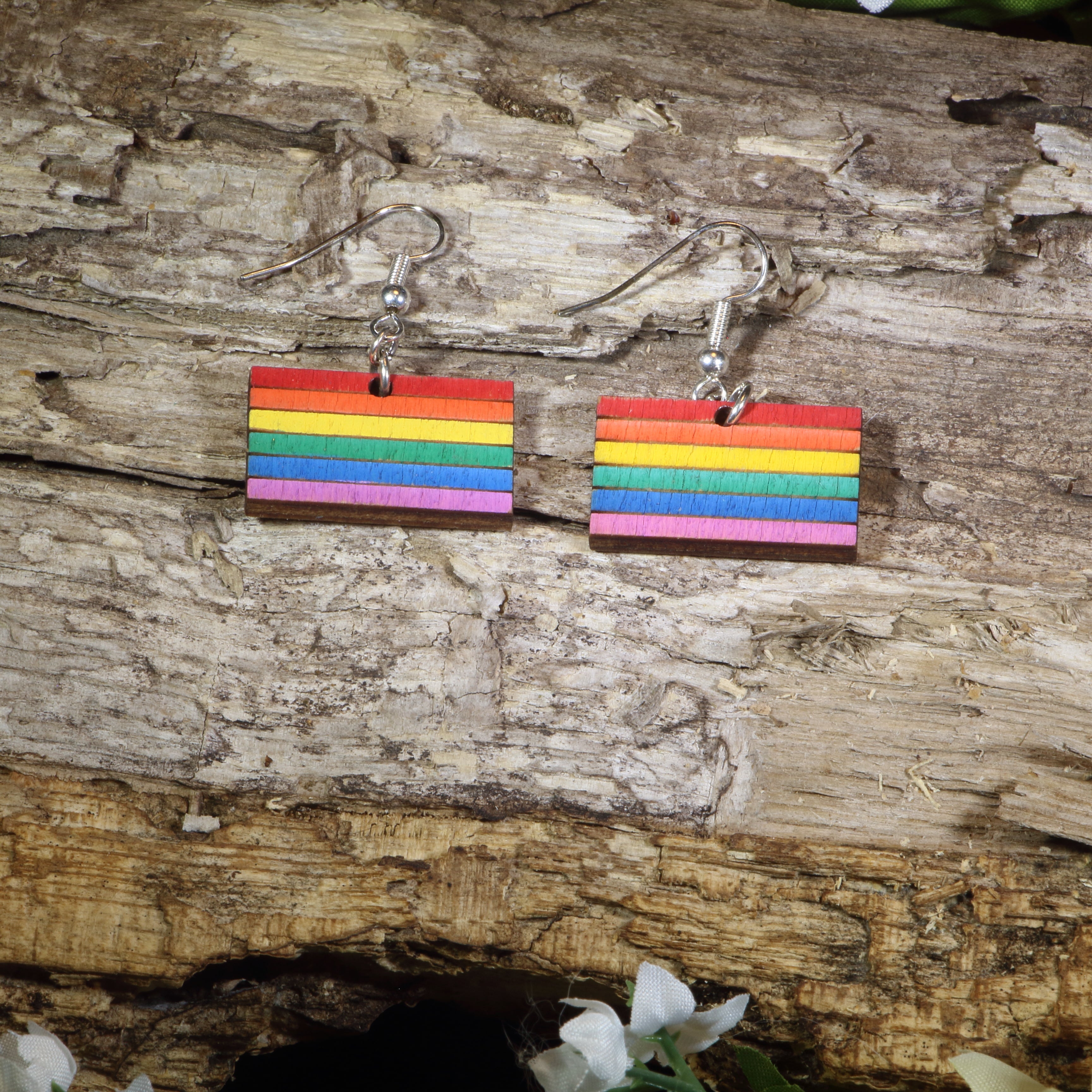 Hand-painted wooden LGBTQ Pride Flag dangle earrings featuring vibrant rainbow flag stripes, hypoallergenic sterling silver hooks, and lightweight LGBTQ+ pride jewelry for advocates, allies, and members of the queer community by Cate&