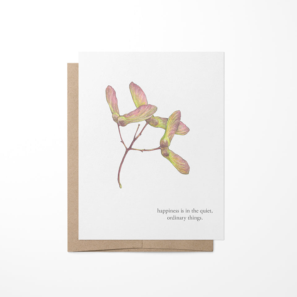 A greeting card with a watercolor painting of maple seeds and a quote by Virginia Wolf on the back. The card is blank inside and comes with a brown kraft envelope.
