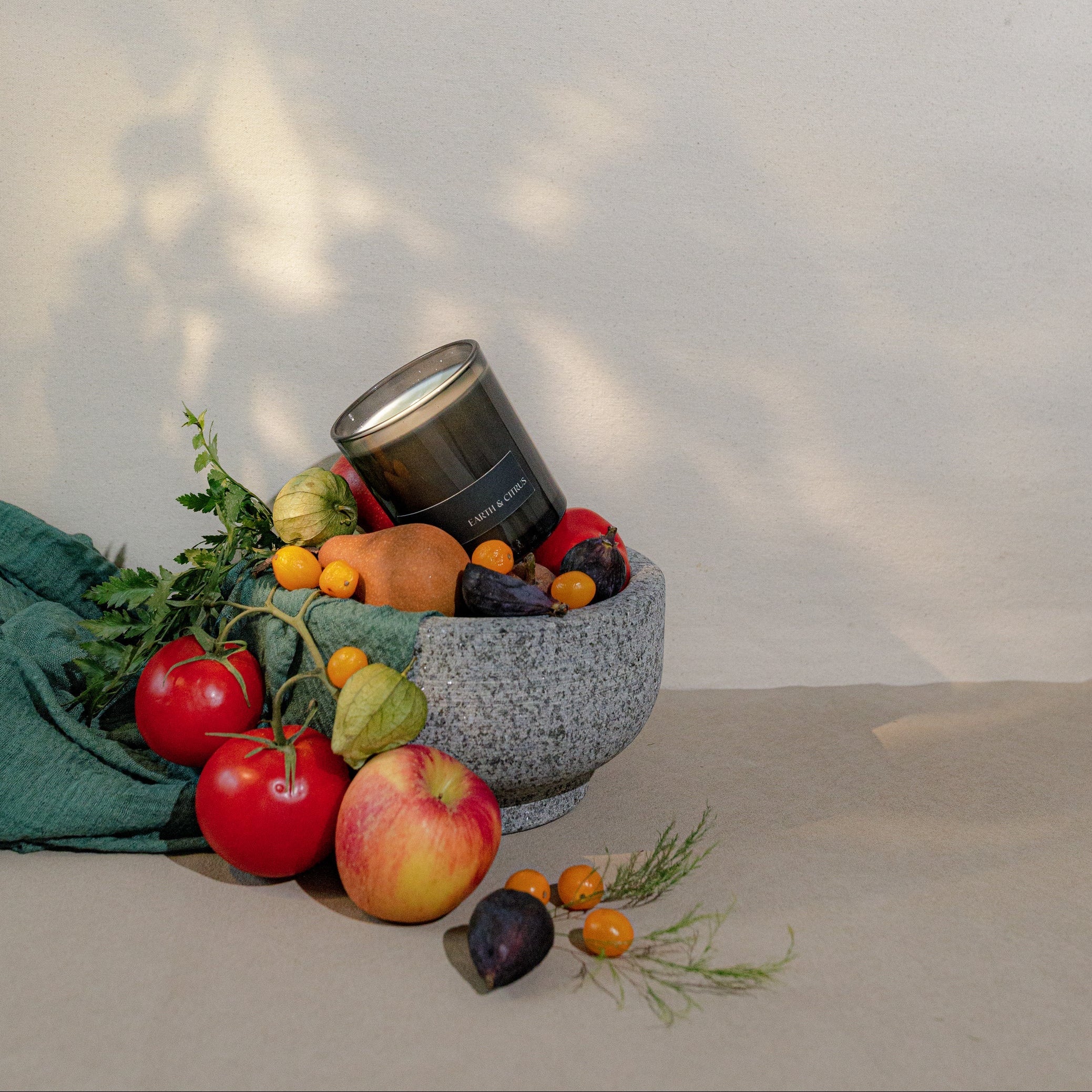 Fruit and vegetable display with a black container on a neutral background