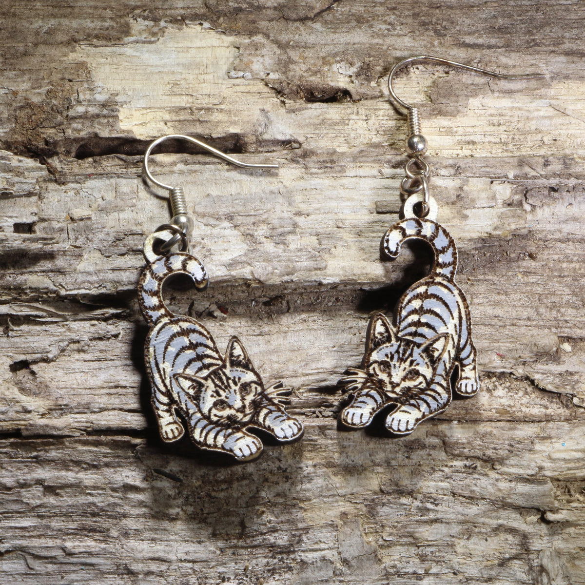 Handcrafted playful gray tabby cat wooden dangle earrings featuring an adorable gray tabby with bright green eyes and a playful pose. Lightweight laser-cut wooden earrings with hypoallergenic .925 sterling silver hooks, perfect for cat lovers, tabby cat owners, pet parents, feline enthusiasts, and unique handmade animal jewelry.