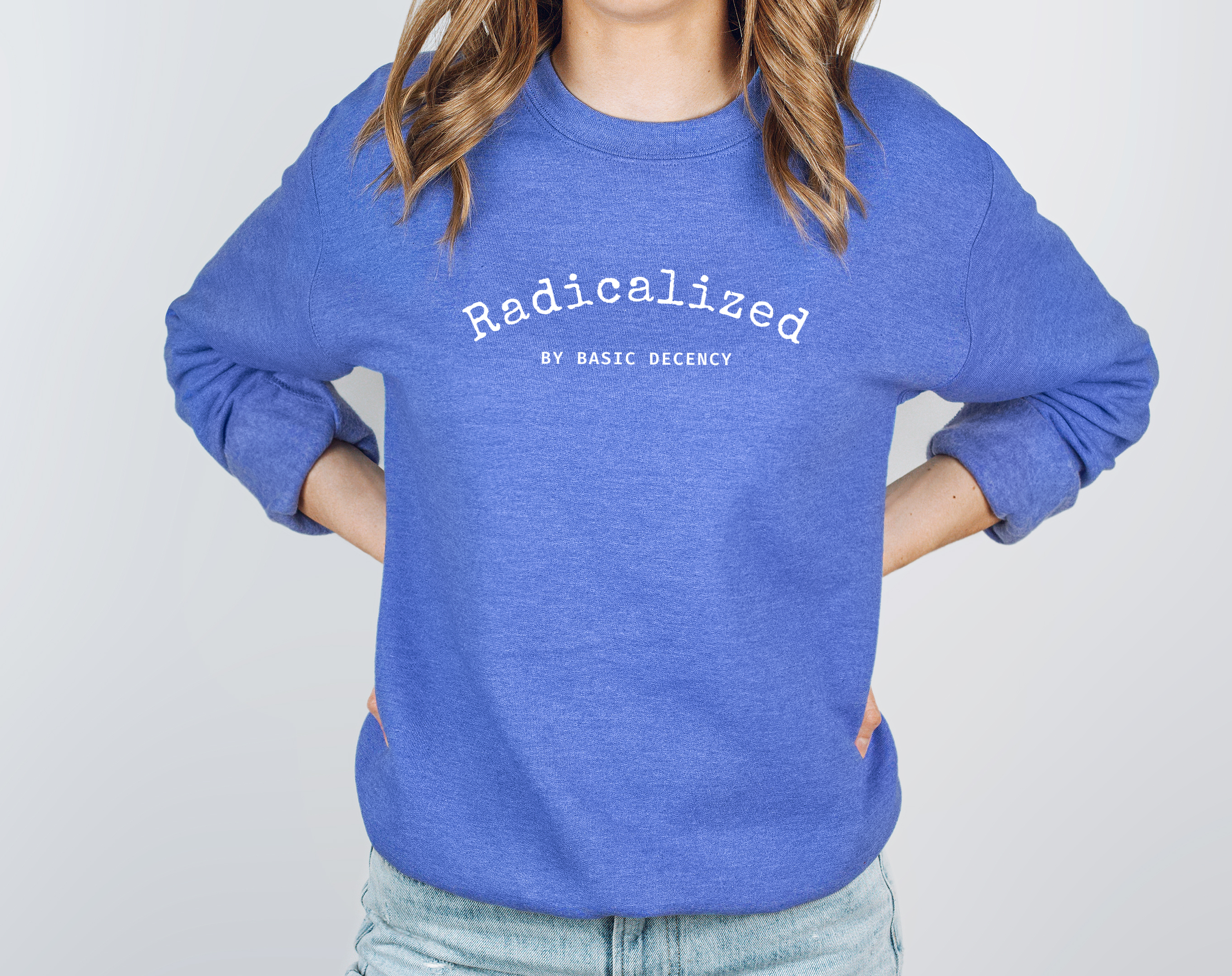Person wearing a blue sweatshirt with white typewriter like text reading radicalized by basic decency on a plain background