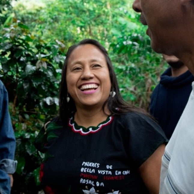 Rosalba smiling while talking with 2 other farmers