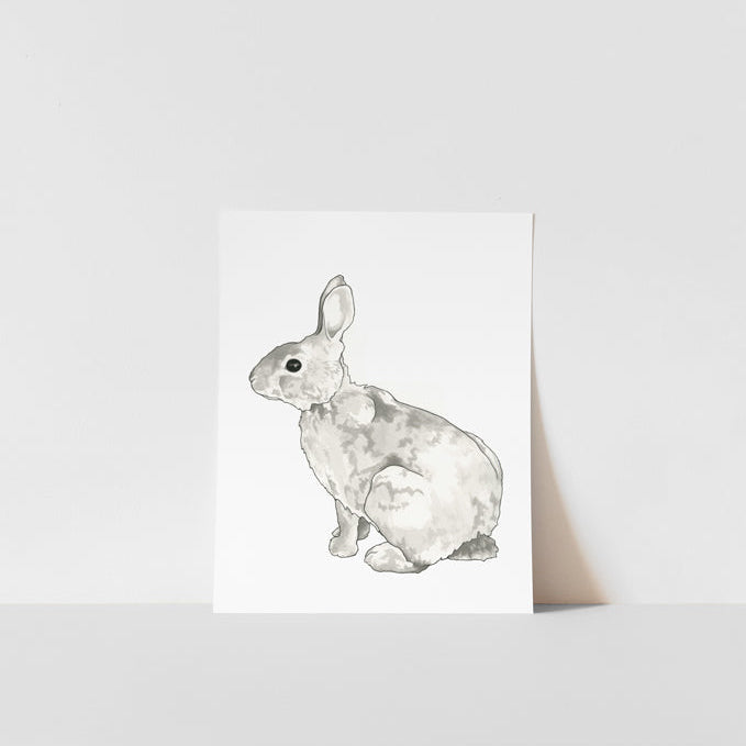 A black and white print of a rabbit on a white background, presented on a simple display shelf.