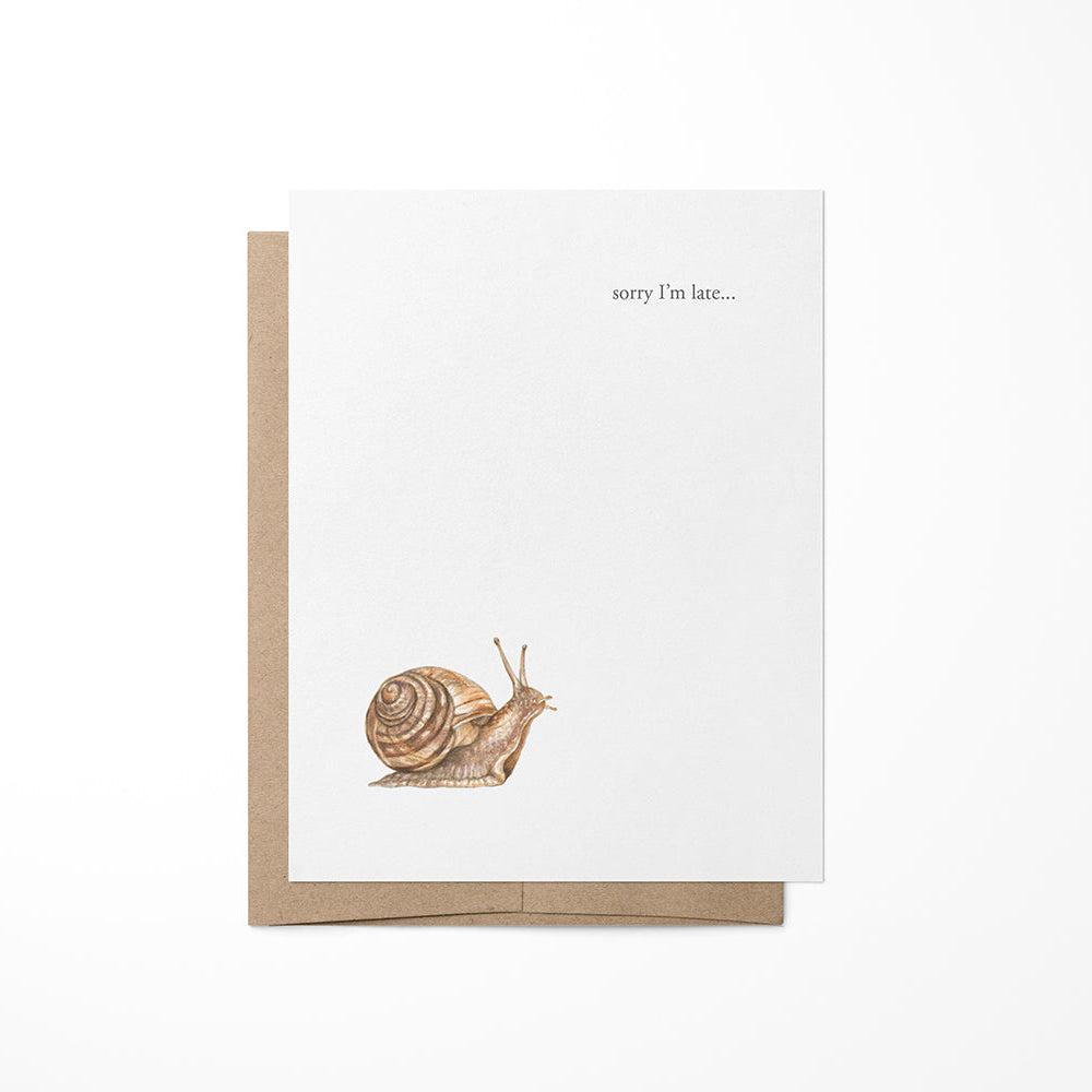 A greeting card with a kraft envelope featuring a small snail illustration and the text &