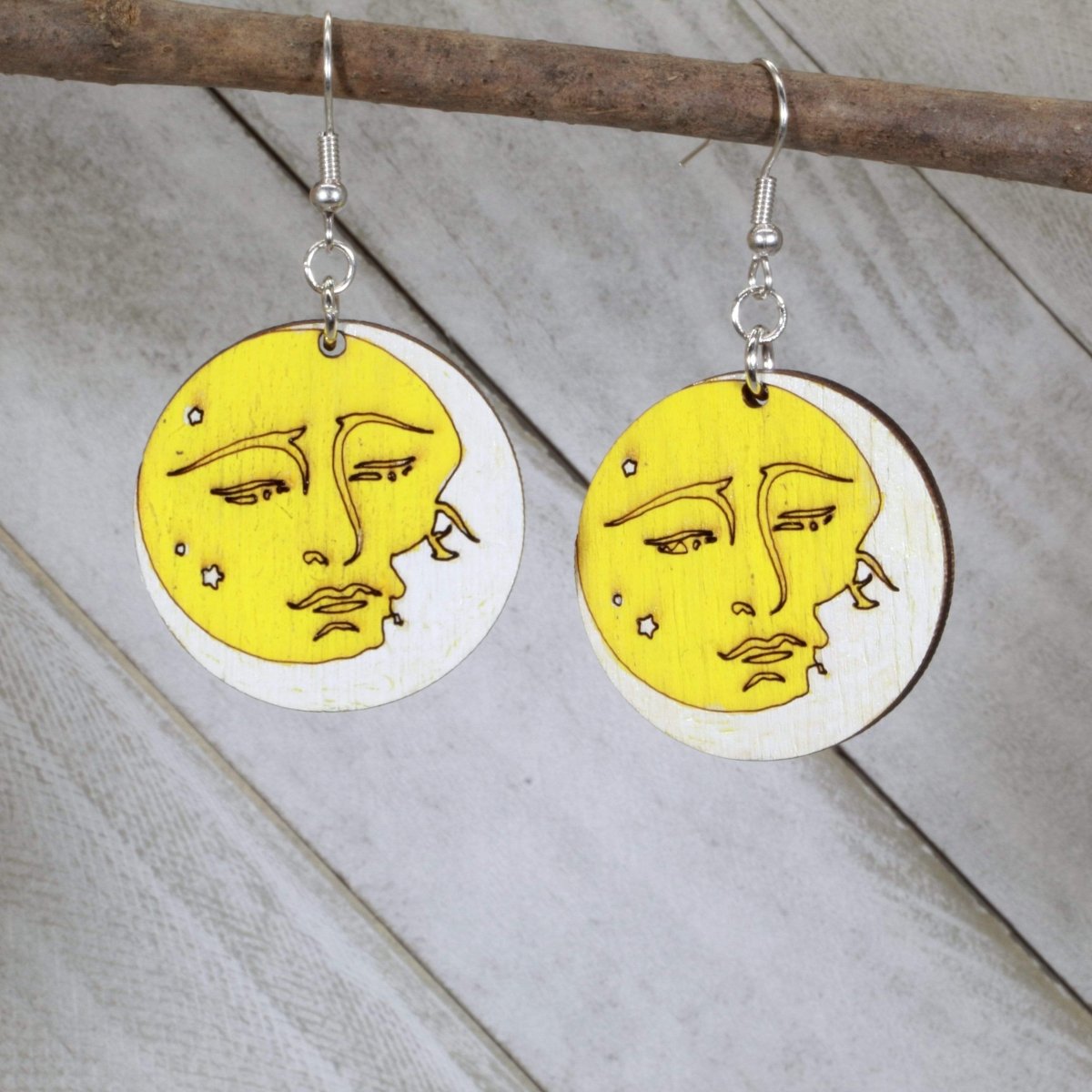 Hand-painted wooden sun and moon dangle earrings featuring a celestial yin yang design with contrasting sun and moon faces and hypoallergenic sterling silver hooks, lightweight jewelry for astrology lovers and boho style enthusiasts by Cate’s Concepts