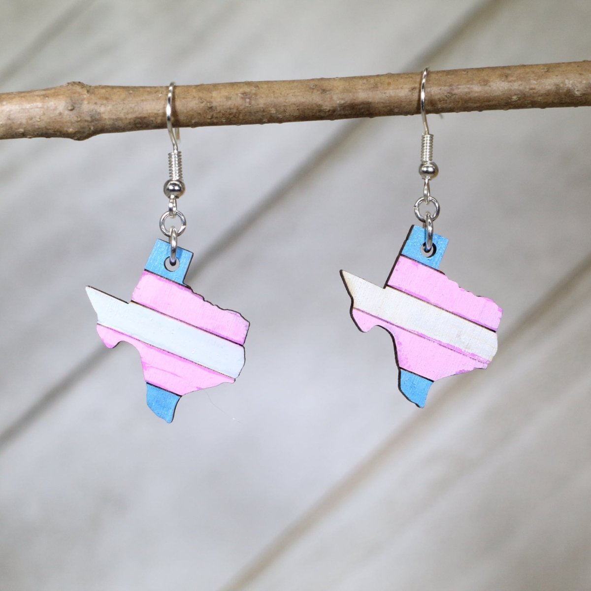 Hand-painted wooden Texas trans pride dangle earrings with transgender flag inspired Texas design and hypoallergenic sterling silver hooks, lightweight LGBTQ statement jewelry earrings for Texas pride and inclusive style