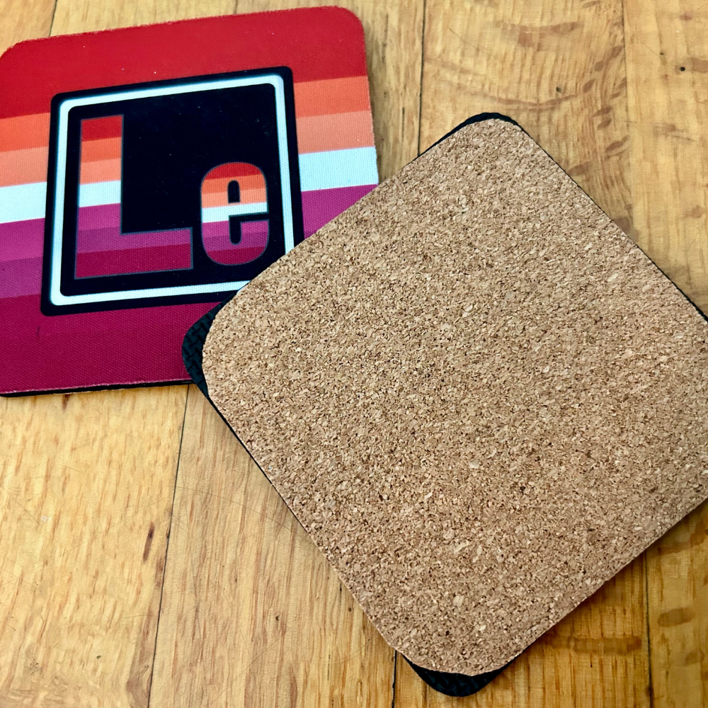 The Lesbian Element coaster. On the left is the front of the Lesbian element with the colors of the lesbian flag. On the right is te back of our coasters, which have cork across the back of the coaster.
