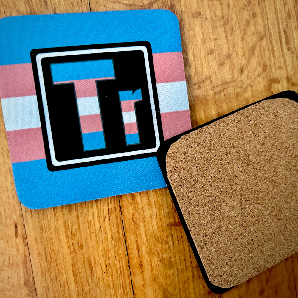 The Trans Element coaster. On the left is the front of the Trans element with the colors of the Trans flag. On the right is te back of our coasters, which have cork across the back of the coaster.