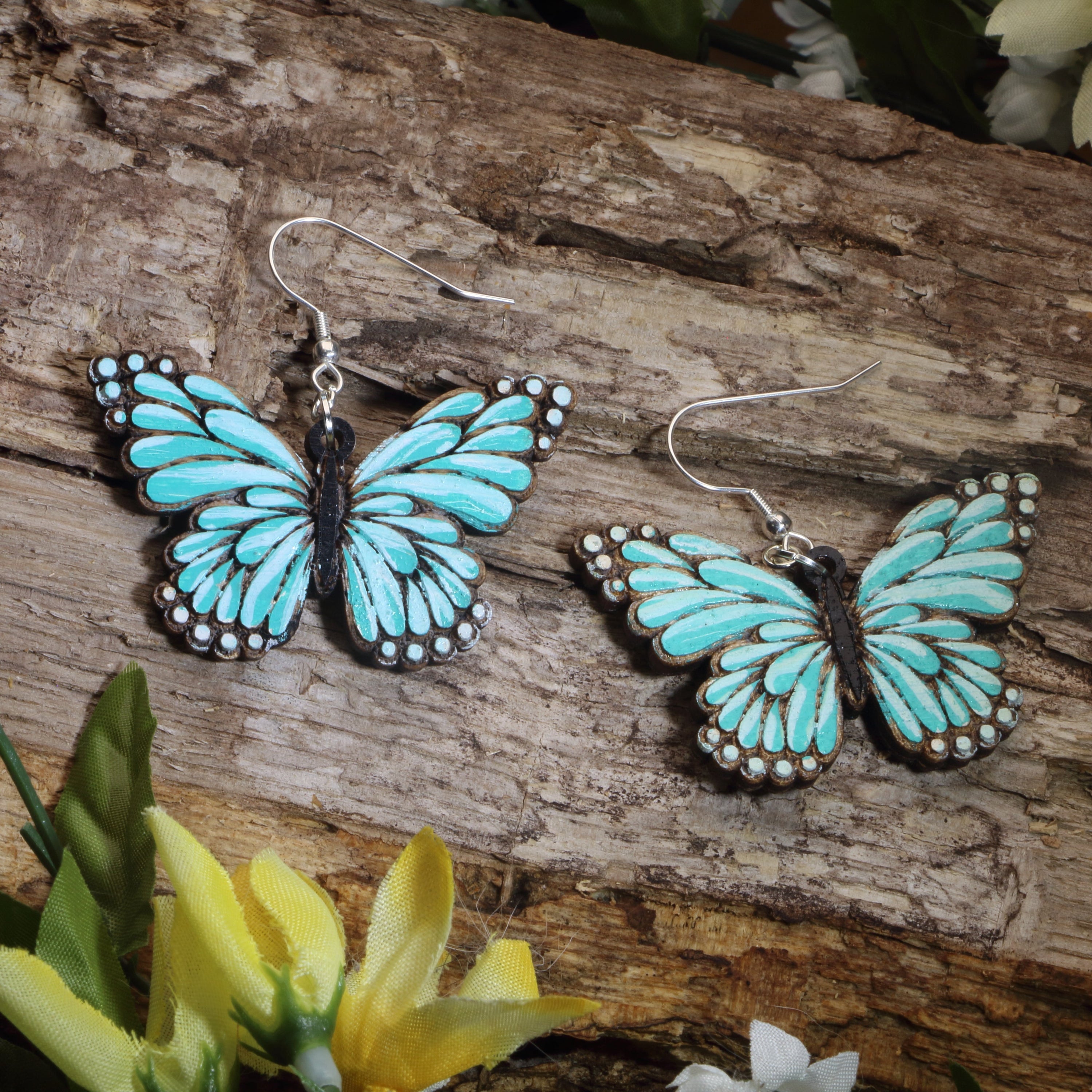 Hand-painted wooden turquoise butterfly dangle earrings with vibrant nature-inspired wing design and hypoallergenic sterling silver hooks, lightweight butterfly jewelry for garden lovers and whimsical everyday style by Cate’s Concepts.
